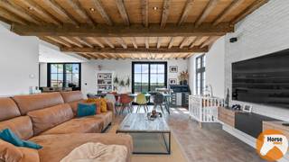 PUTTE – Instapklare woning met polyvalent bijgebouw op ca. 60 are<br /><br />Deze prachtig afgewerkte woning met multifunctioneel bijgebouw bevindt zich op een ruim perceel van ongeveer 60 are. Zowel het hoofdgebouw als het bijgebouw zijn met veel zorg en oog voor detail ingericht.<br /><br />De leefruimte bestaat uit een open geheel van woonkamer, eetkamer en keuken, wat zorgt voor een aangenaam en ruimtelijk gevoel. De keuken straalt warmte uit dankzij de gekozen kleuren en materialen en is volledig uitgerust met alle hedendaagse comfort: koelkast, vaatwasser, spoelbak, microgolfoven en een stijlvol SMEG-fornuis met drie ovens.<br /><br />Aansluitend bevindt zich een praktische bijkeuken met aansluiting voor wasmachine en droogkast, eveneens smaakvol afgewerkt.<br /><br />Vanuit de ruime leefruimte en eetplaats geniet je van een mooi zicht op het terras en de tuin, waardoor binnen en buiten naadloos in elkaar overlopen.<br /><br />Via de houten trap in de inkomhal bereik je de bovenverdieping. Hier bevinden zich drie slaapkamers en een verzorgde badkamer met bad, douche en dubbele lavabo. De warme en harmonieuze stijl van de benedenverdieping wordt ook hier verder doorgetrokken.<br /><br />De woning beschikt bovendien over een volledige kelder.<br /><br />Naast de woning staat een polyvalent bijgebouw met een totale oppervlakte van ongeveer 100 m². Dit gebouw is verwarmbaar en praktisch ingericht, met eveneens zicht op de tuin. Ideaal als gezellige plek voor een zomerse barbecue of een winterse avond met vrienden.<br /><br />Voor paardenliefhebbers is deze eigendom extra aantrekkelijk: er zijn twee paardenstallen, een paddock en weide aanwezig. De weides zijn degelijk afgesloten met een houten omheining.<br /><br />Ben je op zoek naar een instapklare woning waar je je paarden aan huis kan houden? Dan is dit misschien precies wat je zoekt.<br /><br />Voor meer informatie kan je ons steeds contacteren via 053/60.65.66.