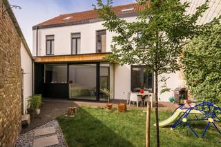 <p><strong>Quares - TREVI Groep presenteert :<br />Prachtige interbellum herenwoning met tuin en garage (vrij beroep mogelijk)</strong></p>
<p>Deze prachtige herenwoning uit het interbellum werd totaal gerenoveerd in 2018. Hierbij werd er gewerkt met kwalitatieve en hoogwaardige materialen alsook werd er rekening gehouden met een optimale indeling van de ruimtes. Een enorm ruimtegevoel werd gecreëerd door grote raampartijen, een goede vormgeving en de juiste oriëntatie waarbij het behoud van authentieke elementen centraal staat. De uitzonderlijk gevelbreedte (+/- 13m) voor een woning in de binnenstad zorgt voor veel daglicht in de ruimtes, zowel op het gelijkvloers als op de verdiepingen.</p>
<p>Bij het betreden van het pand krijg je een instant wauw-gevoel door de hoge plafonds, tegel- en houtvloeren in combinatie met modern comfort en warme materialen. De leef- en eetruimte zijn volledig opengetrokken waarbij je een directe connectie ervaart met de achterliggende tuin. De houthaard zorgt voor extra sfeer en gezelligheid. De semi-open keuken bevindt zich in een L-vorm met de leef-en eetruimte. Hierdoor is de leefkeuken het centrale hart van de woning waar je een leuke interactie kan ervaren tussen koken, aperitieven, gezelligheid en wederom dezelfde connectie met de achterliggende tuin. Door de grote schuiframen kan je een binnen/buiten gevoel creëren waarbij bij zonnig weer deze ruimtes naadloos in elkaar overlopen. De keuken is volledig uitgerust met kasten en toestellen en beschikt naast voldoende opbergruimte over voldoende werkruimte voor de hobbykok. Naast de keuken bevindt zich nog een ruime bergruimte.</p>
<p>Vooraan aan de woning is er een afzonderlijke bureauruimte voorzien, ideaal voor thuiswerk, maar geeft ook opportuniteiten voor vrije beroepen. <br />Verder is er nog een ruime inkomhal met afzonderlijk gastentoilet en ruimte voor vestiaire. <br /><br />Via de trap kan je naar de eerste verdieping. Hier bevinden zich de masterbedroom met dressingruimte. Verder zijn er nog twee zeer ruime slaapkamers, alsook een prachtige badkamer uitgerust met dubbele lavabo, ligbad, en inloopdouche. Er is tevens een afzonderlijk toilet.</p>
<p>Op de tweede verdieping bevinden zich nog een polyvalente ruimte, volledig onder een prachtig houten dakgebinte, dat naar wens kan worden ingericht. Denk aan extra slaapkamers, hobbyruimte, extra kantoorruimte,.. . Hier zijn tevens aansluitingen voorzien voor een tweede badkamer.</p>
<p>De tuin met terras is volledig aangekleed en gezellig ingericht, ideaal om te ontspannen. Er is zowel een zijingang voorzien alsook een toegang naar de overdekte staanplaats die gekoppeld is aan het perceel (toegang via Lange Nieuwstraat). De garage is naast autostalplaats ideaal als fietsenberging en opbergruimte.</p>
<p>Deze woning is ideaal voor mensen die van ruimte en modern comfort houden en de aanwezigheid van zeer veel natuurlijk daglicht in hun woning cruciaal vinden. Daarnaast heeft de woning een zeer laag E-peil en zorgt doorgedreven isolatie aan de binnenzijde voor een aangenaam binnenklimaat. Domoticasysteem bedienbaar via app aanwezig.</p>
<p>De zolder zorgt ervoor dat de koper nog een eigen toets kan aanbrengen aan het pand. <br /><br /></p>
<p>Verder is er nog een ruime, droge kelder met vrije hoogte die extra veel opbergruimte biedt. Er is een regenwaterinstallatie die volledig werd vernieuwd in 2026 waardoor de toiletten, buitenkraan en een kraantje voor poetswater in de bergruimte op regenwater werken (uitbreiding mogelijk naar wasmachine).</p>
<p><br />De woning situeert zich in het hart van de stad, op wandelafstand van openbaar vervoer, winkels, sportfaciliteiten, allen op wandel-/fietsafstand.<br /><br />Laat deze unieke kans niet voorbij gaan.</p>