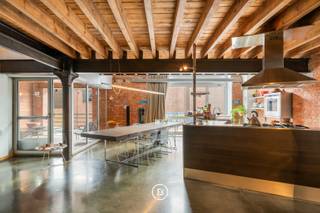 Zelden komt een loft van dit kaliber op de markt. Met een bewoonbare oppervlakte van maar liefst 183 m², indrukwekkende volumes en een uniek duplexconcept biedt deze eigendom een uitzonderlijke woonervaring in residentie “The Big Apple”.<br /><br />Gelegen in een levendige buurt met een vlotte verbinding naar het stadscentrum en het openbaar vervoer, combineert dit appartement stedelijke dynamiek met comfortabel en stijlvol wonen.<br />Op de eerste verdieping bevinden zich een inkomhal met vestiaire en gastentoilet, een polyvalente ruimte die vandaag wordt ingericht als bureau, een open keuken met eetplaats, een praktische provisieberging en een aangenaam inpandig terras van circa 10 m².<br /><br />De bovenverdieping omvat een indrukwekkende open leefruimte, een ruime masterbedroom met ensuite dressing en een stijlvolle badkamer.<br /><br />De hoge plafonds, open indeling en karaktervolle architectuur zorgen voor een authentieke loftbeleving met een unieke uitstraling. Dit instapklare appartement is ideaal voor wie op zoek is naar ruimte, licht en karakter in een bijzondere woonomgeving.