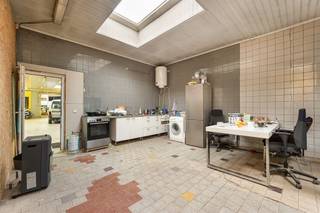 <p><span> </span></p><p><span>Op zoek naar een pand met massa’s ruimte én mogelijkheden? Dit veelzijdige gebouw combineert een gigantisch magazijn met meerdere woonentiteiten op een sterke locatie vlakbij het Rivierenhof. Ideaal voor wie wonen en werken wil combineren, of voor investeerders die mikken op rendement. </span></p><p><span> </span></p><p><span>Wonen, werken of investeren</span></p><p><span>Volgens de laatst vergunde plannen gaat het om twee appartementen, een winkelruimte en een magazijn. Vandaag wordt het gelijkvloers deels gebruikt als appartement (verhuurd aan €1000/maand) en is er een ruim magazijn aanwezig, bereikbaar via een grote garagepoort. </span></p><p><span>Het gebouw ademt geschiedenis – ooit deed het dienst als vleeswarenfabriek – en dat voel je aan de indrukwekkende volumes en robuuste structuur. Het magazijn strekt zich uit over een enorme oppervlakte, met verschillende werkplaatsen, open ruimtes en opslagzones. Perfect voor zelfstandigen, opslag, ateliers of herontwikkeling.</span></p><p><span>Naast het magazijn vind je op het gelijkvloers onder meer een bureel, keuken, sanitaire voorzieningen en meerdere polyvalente ruimtes. </span></p><p><span> </span></p><p><span>Appartementen met potentieel</span></p><p><span>Op de eerste verdieping zijn er twee aparte entiteiten:</span></p><p><span>Aan de achterzijde bevindt zich een atelier met aansluitend een appartement, momenteel verhuurd aan €500/maand.</span></p><p><span>Aan de voorzijde ligt een ruim appartement van ca. 100 m² met groot terras. Deze unit staat leeg en dient nog verder afgewerkt te worden – een mooie opportuniteit om naar eigen smaak te finaliseren.</span></p><p><span>Op de tweede verdieping bevindt zich een instapklaar appartement van ca. 70 m², met leefruimte, keuken, slaapkamer en badkamer. Ideaal als extra verhuureenheid of voor eigen bewoning.</span></p><p><span> </span></p><p><span>Groots magazijn met eindeloze mogelijkheden</span></p><p><span>Het absolute paradepaardje is zonder twijfel het enorme magazijn op het gelijkvloers. De hoge plafonds, brede overspanningen en grote garagepoort maken laden en lossen bijzonder eenvoudig. Dit volume leent zich perfect voor stockage, productie, creatieve invulling of een combinatie van wonen en werken onder één dak.</span></p><p><span>Dankzij de solide structuur en de oppervlakte biedt dit pand tal van herontwikkelingsmogelijkheden, steeds binnen de geldende stedenbouwkundige voorschriften.</span></p><p><span> </span></p><p><span>Groen en centraal in Deurne-Zuid</span></p><p><span>Je zit hier op een goede locatie in Deurne-Zuid, vlakbij het Rivierenhof. Winkels, openbaar vervoer en invalswegen bevinden zich op korte afstand. Een strategische ligging voor zowel residentieel als professioneel gebruik.</span></p><p><span>De combinatie van bereikbaarheid, ruimte en indeling maakt dit pand bijzonder interessant voor investeerders, ondernemers of grote gezinnen die veel plaats zoeken.</span></p><p><span> </span></p><p><span>Maatregelenregister: in aanvraag</span></p><p><span> </span></p>