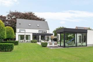 <p><span>Luxe villa met zwembad en poolhouse vlakbij het centrum van Hoogstraten</span></p><p><span>Op een rustige, maar centrale ligging nabij het centrum van Hoogstraten werd in 2019 deze ruime villa volledig gerenoveerd tot nieuwbouw staat. Deze verrassend ruime woning biedt ca. 425 m² woonruimte!</span></p><p><span> </span></p><p><span>Indeling</span></p><p><span>U betreedt de woning middels de inkomhal met gastentoilet en trap naar verdieping, door een grote glazen deur heeft u bij binnenkomst al doorzicht tot in de tuin. Vanuit de inkomhal ook toegang tot een bureelruimte aan de voorzijde van de woning. De zeer ruime leefruimte heeft een prachtig zicht naar de tuin en veel natuurlijk lichtinval. De woonruimte heeft aan de straatzijde een speelkamer of tweede bureel, zitkamer gedeelte met gashaard, centrale eetplaats en open keuken met groot eiland met ontbijtgedeelte. De keuken is hoogwaardig afgewerkt en voorzien van diverse inbouwtoestellen. Vanuit de keuken een doorgang naar de bijkeuken en wasplaats en toegang tot de kelder met bijkomende bergruimte.</span></p><p><span> </span></p><p><span>Verdieping</span></p><p><span>Via de moderne trap met indirecte verlichting bereikt men de nachthal met toegang tot de ruime mastersuite bestaande uit een slaapkamer, dressingkamer met ingemaakte kasten, en ruime badkamer. Nog twee zeer ruime kinderkamers met ingemaakte kasten en een tweede badkamer. Alle kamers zijn voorzien van rolluiken.</span></p><p><span> </span></p><p><span>Tweede verdieping</span></p><p><span>Ook de tweede etage werd volledig ingericht en afgewerkt en voorziet een ruime polyvalente ruimte welke momenteel in dienst is als bureelruimte, tevens een bergzolder en een technische ruimte .</span></p><p><span> </span></p><p><span>Kelder</span></p><p><span>Vanuit de bijkeuken bereikt u de kelder welke u bijkomende koele bergruimte biedt.</span></p><p><span> </span></p><p><span>Poolhouse</span></p><p><span>Het vrijstaande poolhouse biedt een multifunctionele ruime welke kan worden gebruikt als ontspanningsruimte, feestzaaltje of fitness. Er zijn diverse voorzieningen zoals een ingerichte keuken met diverse toestellen (vaatwasser, oven, koelkast met vriezer) alsook sanitaire voorzieningen met douche en toilet.</span></p><p><span> </span></p><p><span>Tuin, zwembad en buitenruimtes</span></p><p><span>De mooie aangelegde tuin geniet van een zuid oriëntatie en veel privacy, de ruime terrassen rondom het verwarmde zwembad bieden ruimte voor lounge en tuinmeubilair. Achterin de tuin is nog speelruimte voor de kinderen voorzien</span></p><p><span> </span></p><p><span>Parkeren</span></p><p><span>Naast en voor de villa werden parkeerplaatsen voorzien met laadinfrastructuur voor elektrische voertuigen.</span></p><p><span> </span></p><p><span>Bijzonderheden</span></p><p><span>Deze ruime woning is technisch volledig up to date en werd in 2019 volledig gerenoveerd tot nieuwbouwstaat. De villa is uitgerust met domotica, vloerverwarming met warmtepomp (geothermie) en tevens passieve koeling op gelijkvloers en 1e verdieping. Geboorde put, tuin beregening, omheinde tuin met terrassen, verwarmd zwembad met automatisch rolluik, poolhouse met bar, keuken, toilet en douche. Ventilatiesysteem, E peil = 3 (BEN woning), zonnepanelen 11 KW. Op de eerste verdieping zijn alle ramen voorzien van rolluiken. De ramen aan de zuidgevel (achtergevel) werden voorzien van screens, alsook werd een oversteek voorzien om optimale lichtinval te genieten, afhankelijk van het seizoen.</span></p>