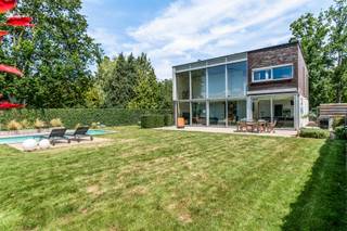 Deze moderne vrijstaande woning op de grens met Brasschaat in de Claessensdreef is rustig gelegen, vlak bij het groen van de Kattekensberg, en toch op amper vijf minuten van het centrum van Brasschaat en Kapellen. <br /><br />Bij het binnenkomen kom je in een ruime inkomhal. Rechts vindt u een gastentoilet en een aparte vestiaire. Verder in de gang richting de leefruimte is er een toffe bureauruimte op de linkerkant discreet weggewerkt.<br /><br />Recht voor u opent de woning zich in een lichtrijke leefruimte met open keuken. De vide tot aan het dak boven het salon geeft een gevoel van ruimte. de achtergevel, bijna volledig in glas, haalt de zuidelijke tuin naar binnen. Bovendien zijn alle ramen aan de achterzijde voorzien van zonnewering. Naast de leefruimte ligt een sfeervolle extra kamer, vandaag gebruikt als tv- en leeshoek. Een doorkijkhaard verbindt beide ruimtes visueel, en zorgt voor extra gezelligheid op koude avonden. <br /><br />De open keuken sluit aan op een praktische aparte berging, met rechtstreekse toegang tot de inpandige garage met elektrische poort. <br /><br />Via de inkomhal leidt de trap naar de eerste verdieping, waar u drie ruime slaapkamers vindt waarvan 2 voorzien van airco, twee badkamers en een aparte wasberging. Eén slaapkamer beschikt over een eigen dressing en ensuite badkamer.<br /><br />Buiten wacht een groot perceel. Vooraan een ruime oprit met plaats voor minstens 4 wagens, achteraan een prachtige, private tuin die de hele dag zon vangt dankzij de zuidoriëntatie. Het recent vernieuwd, verwarmbare ingebouwde zwembad vormt zonder twijfel de blikvanger van deze buitenruimte.<br /><br />Bijzonderheden:<br />- EPC C<br />- Elektriciteit conform<br />- Zonnepanelen<br />- Bamboe parket<br />- Vloerverwarming<br /><br />Attesten (EPC, EK) zijn beschikbaar via onze website: https://jamar.immo/<br />Wg – Vg – Gvkr – Gvv – Gmo – Geen overstromingsgevoelig gebied – Geen Worg