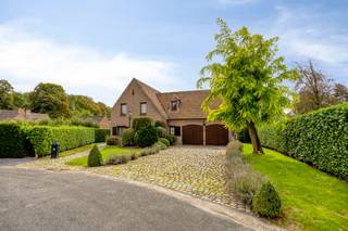 Mooie klassieke villa, ideaal gelegen in een doodlopende straat van een gegeerde residentiële wijk, op een zuidgericht perceel van 10a03ca.<br /><br />De woning biedt mooie volumes, veel lichtinval en een polyvalente indeling. Op het gelijkvloers leidt een ruime inkomhal met vestiaire en apart toilet naar een lichtrijke leefruimte met open plafond tot in de nok en een open haard, evenals een volledig ingerichte keuken met recente toestellen. Twee slaapkamers (14 m² en 13 m²) en een badkamer vervolledigen dit niveau, dat dankzij de indeling ook perfect kan functioneren als afzonderlijke leefruimte voor ouders, oudere kinderen, gasten of een professionele activiteit. <br /><br />Op de eerste verdieping bevindt zich een open mezzanine die kan dienen als bureau of speelruimte, drie bijkomende slaapkamers — waarvan één met privatieve badkamer en ingemaakte kasten — en een douchekamer.<br /><br />De zuidgerichte tuin biedt een aangename buitenruimte. Het terras van 21 m², deels overdekt, beschikt over een ingebouwde barbecue. Een garage voor twee wagens en een uitzonderlijke droge kelder van 85 m² — ideaal voor stockage, atelier of wijnkelder — maken het geheel compleet.<br /><br />Modern comfort: airconditioning, condenserende gasketel en overal dubbele beglazing. Elektrische installatie conform. Asbestveilig. EPC: D.