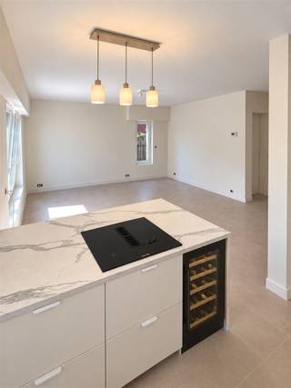 <p><span>Volledig gerenoveerd 1-slaapkamerappartement met ca. 40 m² buitenruimte in Schoten</span></p><p><span>Op een </span><span>uiterst rustige locatie in Schoten</span><span>, op wandelafstand van het kanaal, bevindt zich dit </span><span>volledig gerenoveerde gelijkvloerse appartement</span><span> met één slaapkamer en maar liefst </span><span>ca. 40 m² private buitenruimte</span><span>.</span></p><p><span>Het appartement werd grondig en kwalitatief gerenoveerd. </span><span>Alle leidingen en technieken werden vernieuwd</span><span>, het appartement werd geïsoleerd en voorzien van </span><span>vloerverwarming</span><span>. Ook de ramen werden volledig vernieuwd en zijn uitgerust met </span><span>elektrische rolluiken</span><span>.</span></p><p><span>Via de inkomhal betreed je het appartement. Hier bevindt zich een praktische ingebouwde kast met ruimte en aansluitingen voor </span><span>wasmachine en droogkast</span><span>, waardoor deze netjes uit het zicht kunnen worden geplaatst.</span></p><p><span>De lichtrijke leefruimte sluit naadloos aan op de </span><span>volledig uitgeruste open keuken</span><span>. Deze beschikt over een koelkast, diepvries en een </span><span>Bosch oven en microgolfoven</span><span>. Het ruime kookeiland is voorzien van een kookplaat met </span><span>geïntegreerde dampafzuiging</span><span> en een </span><span>ingebouwde wijnkast</span><span>. De stijlvolle verlichting boven het eiland zorgt voor extra sfeer. Dankzij de oversteek van het werkblad is er bovendien voldoende plaats om enkele barkrukken te plaatsen.</span></p><p><span>Het appartement beschikt over </span><span>één slaapkamer</span><span>, bereikbaar via een mooi geïntegreerde schuifdeur. Ook de badkamer is voorzien van een ingebouwde schuifdeur en werd met veel aandacht voor detail afgewerkt. Ze beschikt over een toilet, een stijlvol badkamermeubel met </span><span>natuurstenen waskom</span><span>, een </span><span>verlichte en verwarmde spiegel</span><span> en een </span><span>zeer ruime inloopdouche</span><span>.</span></p><p><span>Ook aan buitenruimte is er geen gebrek. Aan de achterzijde bevindt zich een </span><span>volledig omheind terras van ca. 25 m² met westoriëntatie</span><span>, ideaal om te genieten van de namiddag- en avondzon. Via een afsluitbaar poortje is het appartement bovendien rechtstreeks langs het terras toegankelijk.</span></p><p><span>Daarnaast beschikt het appartement over het </span><span>private gebruik van ca. 15 m² tuin aan de voorzijde van het appartementsgebouw</span><span>. Samen biedt dit appartement dus maar liefst </span><span>ca. 40 m² private buitenruimte</span><span>, verdeeld over de voor- en achterzijde.</span></p><p><span>Een </span><span>volledig instapklaar appartement</span><span> met een hoogwaardige afwerking, hedendaags wooncomfort en een bijzonder rustige ligging op wandelafstand van het kanaal.</span></p><p><span>Garagebox optioneel bij aan te kopen aan 25.000 €.</span></p><p><span>Troeven:</span><span> </span></p><p><span>- volledig gerenoveerd </span></p><p><span>- vloerverwarming vernieuwde leidingen en technieken</span></p><p><span>- geïsoleerd </span></p><p><span>- lage EPC</span></p><p><span>- asbestvrij</span></p><p><span>- nieuwe ramen met elektrische rolluiken  </span></p><p><span>- uiterst rustige ligging nabij het kanaal </span></p><p><span> </span></p><p><span>Lage gemeenschappelijke kosten want geen lift aanwezig!</span></p>
