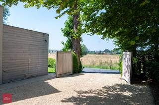 Een oase van rust. Afgeschermd door parktuin met vijver en volgroeide bomen bevindt zich deze villa bestaande uit een inkomhall, living met open hard en eetplaats, ingerichte keuken, bijkeuken, grote wasplaats, 3 slaapkamers (1 gelijkvloers), badkamer. Bijgebouw (plaats voor 2 wagens en opslag) en extra garage. Electriciteit conform. Zicht op landerijen en de Poelberg.
