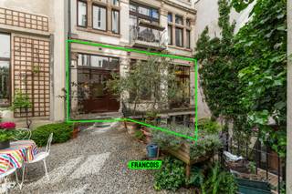 In een karaktervolle mede-eigendom met drie blokken en een authentiek industrieel cachet bevindt zich dit uitzonderlijke duplex loft appartement in het historisch centrum van Brussel met een bewoonbare oppervlakte van 202 m² volgens EPC. De loft is gelegen op het gelijkvloers en strekt zich uit over twee niveaus, waarbij ruimte, licht en comfort centraal staan.<br /><br />Bij het betreden van het appartement wordt u verwelkomd in een bijzonder lichtrijke leefruimte die dankzij grote raampartijen een aangename openheid creëert en naadloos overgaat in het idyllische gemeenschappelijke terras. Aansluitend bevindt zich de open, volledig uitgeruste keuken die perfect geïntegreerd is. <br /><br />Op de benedenverdieping bevinden zich twee volwaardige slaapkamers, elk voorzien van een eigen ensuite badkamer. De eerste badkamer is uitgerust met een inloopdouche en lavabo, terwijl de tweede badkamer een hoger niveau van comfort biedt met een ligbad, inloopdouche, dubbele wastafel en toilet. <br /><br />Verder beschikt het appartement over een privatief terras, een apart gastentoilet en tal van ingemaakte kasten die zorgen voor optimale bergruimte. Hierin zijn ook de voorzieningen voor de wasmachine en de elektrische waterboiler discreet ondergebracht.<br /><br />Divers: Dubbele beglazing in houten raamprofielen, centrale verwarming op aardgas, elektriciteit conform, waterverzachter en filter aanwezig, fietsenlokaal, gemeenschappelijke kelder, dak en deel façade recent geïsoleerd, parketen tegelvloeren, ventilatiesysteem aanwezig, alarmsysteem en syndicuskosten +-€300/maand (inclusief verwarming)<br /><br />Deze unieke loft combineert industriële charme met hedendaags wooncomfort en vormt een zeldzame opportuniteit op een toplocatie in Brussel.<br /><br />