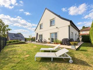 <strong>SPATIEUZE VILLA</strong> met <strong>VOLLEDIGE ONDERKELDERING (90M²)</strong> en een <strong>ZONOVERGOTEN TUIN</strong> op een rustige ligging. Voorzien van <strong>EPC-LABEL B</strong>, dankzij de aanwezige I<strong>SOLATIE EN 32 ZONNEPANELEN</strong>. Bovendien werd het <strong>DAK RECENT VERNIEUWD (2024)</strong>, de <strong>OPRIT HERAANGELEGD</strong> en de <strong>GEVEL PAS OPNIEUW GESCHILDERD</strong>. Deze instapklare woning met <strong>ROYAAL BEWOONBAAR OPPERVLAK </strong>van ca. <strong>236M²</strong> verwelkomt u via de inkomhal en biedt een aangename, uiterst lichtrijke leefruimte die naadloos aansluit op de eetplaats en de <strong>VERNIEUWDE OPEN KEUKEN</strong>. Het grote kelderverdiep van <strong>CA. 90M²</strong> omvat een <strong>PRAKTISCHE BERGING</strong>, wasplaats, werkatelier en <strong>INPANDIGE GARAGE</strong>, wat zorgt voor uitzonderlijk <strong>VEEL OPSLAG- EN WERKRUIMTE</strong>. Op de verdieping bevinden zich <strong>DRIE RUIME SLAAPKAMERS </strong>met ingemaakte kasten, aparte dressing en een luxueuze badkamer uitgerust met zowel ligbad als ruime inloopdouche. Buiten geniet u van ruime oprit, zonnige tuin met een <strong>MOOI GROEN UITZICHT</strong> en een <strong>AANGENAAM TERRAS</strong> waar het heerlijk vertoeven is. De villa is gelegen in een <strong>RUSTIGE STRAAT</strong>, op korte afstand van het <strong>STATION</strong> en met vlotte verbindingen naar omliggende gemeenten en <strong>BELANGRIJKE INVALSWEGEN</strong>.<br /><br />Adres: Stikte 1 te Geraardsbergen (Moerbeke)<br /><br />Geen renovatieplicht; P-score: A, G-score: A; Bestuursmaatregelen in maatregelenregister: neen.