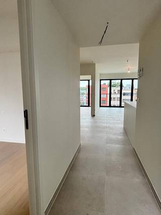 Dit nieuwbouwappartement op de 3de verdieping van het project De Groene Poort geniet van een uitstekende ligging in de nieuwe dynamische wijk Slachthuisbuurt, aan het Lobroekplein en het Kalverweipark. 

Het appartement heeft een centrale ligging, vlakbij de grote invalswegen en toch op fietsafstand  (10 minuten) van centrum Antwerpen. 

Dit nieuwbouw appartement beschikt over twee slaapkamers en een open, lichte leefruimte. De keuken is stijlvol ingericht met witte kasten en een eiland, voorzien van alle nodige apparatuur. Grote raampartijen bieden veel natuurlijk licht en toegang tot een balkon, waar u kunt genieten van het uitzicht op Lobroekplein. 

De afwerking is van hoog niveau, met een uniforme tegelvloer door de gehele leefruimte en keuken, en een stijlvolle houten vloer in de slaapkamer. Het neutrale kleurenpalet zorgt voor een rustige sfeer en biedt een perfecte basis om uw eigen interieurstijl te creëren. De badkamer is uitgerust met een dubbele lavabo en comfortabele inloopdouche. 

Dit appartement combineert hedendaags comfort met duurzaamheid. De uitstekende isolatie en moderne technieken zorgen voor een lage energiefactuur. Gelegen op een strategische locatie, biedt dit appartement een unieke kans voor wie op zoek is naar kwaliteit en efficiëntie op een toplocatie in Antwerpen. 

Huurders kunnen genieten van de prachtig ingerichte gemeenschappelijke tuin. 

Onmiddellijk beschikbaar. 

Vaste kosten bedragen €200/maand (incl. Kosten voor verwarming en warm water op basis van voorschot)