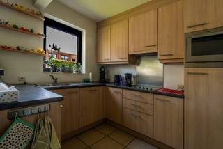 <p>Dit verzorgde gelijkvloerse appartement combineert comfortabel wonen met een uiterst praktische ligging. Dankzij de veilige residentie en de aanwezigheid van een eigen afgesloten garage in de ondergrondse parkeergarage vormt dit appartement een ideale woonst voor zowel eigen bewoning als investering.</p>
<p>Via de gemeenschappelijke inkomhal, uitgerust met een lift en trap naar de ondergrondse verdieping, bereikt u het appartement. De privatieve inkomhal beschikt over een gastentoilet en biedt toegang tot alle woonvertrekken. De aangename leefruimte van circa 32 m² geniet van een natuurlijke lichtinval en sluit naadloos aan op de open keuken van ongeveer 7 m². De badkamer, met een oppervlakte van circa 7 m², is volledig uitgerust met een douche, ligbad en een dubbele lavabo geïntegreerd in een badkamermeubel.</p>
<p>Het appartement beschikt over twee volwaardige slaapkamers van respectievelijk ongeveer 11 m² en 15 m². Beide kamers geven rechtstreeks uit op het ruime achterliggende terras, waar u in alle rust kunt genieten van de buitenruimte.</p>
<p>In de ondergrondse verdieping bevindt zich de privatieve garage, afgesloten met een kantelpoort, wat zorgt voor extra comfort en veiligheid.</p>
<p>De ligging vormt zonder twijfel een belangrijke troef. De bakker bevindt zich letterlijk naast de deur, terwijl supermarkt, openbaar vervoer, gezondheidsvoorzieningen en tal van andere dagelijkse voorzieningen op wandelafstand bereikbaar zijn. Hierdoor geniet u van een uitzonderlijk wooncomfort waarbij alles binnen handbereik ligt.</p>
