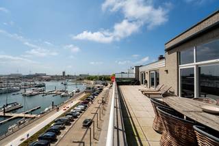 Ontdek deze exclusieve penthouse met panoramisch uitzicht over de jachthaven én achterhaven van Zeebrugge. Een uitzonderlijke woonbeleving met ongeëvenaarde zichten, royale zonneterrassen en een luxueuze afwerking tot in de kleinste details.
Via een stijlvolle inkomhal komt u binnen in een indrukwekkende leefruimte met hoge plafonds, grote raampartijen en directe toegang tot twee ruime terrassen. De overvloed aan natuurlijk licht, gecombineerd met het open uitzicht, creëert een unieke sfeer van rust en verfijning.
De moderne open keuken met centraal eiland is volledig uitgerust met hoogwaardige toestellen en biedt alle comfort. Een aparte leeshoek en een gezellige haard zorgen voor een warme en huiselijke sfeer.
De penthouse beschikt over drie volwaardige slaapkamers, telkens voorzien van ingemaakte kasten en rechtstreekse toegang tot de terrassen. Twee stijlvolle badkamers – één met ligbad en één met inloopdouche – garanderen dagelijks comfort. Daarnaast zijn er twee aparte toiletten en een praktische berging.
Extra troef: mogelijkheid tot aankoop van een bovengrondse dubbele garagebox.
Bent u op zoek naar een uniek en luxueus verblijf aan de jachthaven van Zeebrugge? Aarzel dan niet om contact op te nemen met makelaar Stéphanie via 0472 77 86 60 of stephanie@keyimmo.be voor een exclusief bezoek.