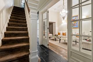 Aan de statige Jan Van Rijswijcklaan in Antwerpen prijkt dit sublieme herenhuis in Neo-Lodewijk XVI-stijl, een architecturaal juweel ontworpen door Edward Van Not in 1912, een naam die synoniem staat voor verfijning, symmetrie en onmiskenbare grandeur.<br /><br />Achter de sierlijke, evenwichtige gevel ontvouwt zich een woning waar ambacht, elegantie en comfort samensmelten tot een zeldzaam harmonisch geheel. Elk detail, van de hoge plafonds met lijstwerk tot de authentieke parketvloeren en marmeren open haarden, ademt karakter en verfijning.<br /><br />De leefruimtes baden in licht dankzij de hoge ramen en creëren een sfeer van stille luxe: groots, maar nooit overdreven. De indrukwekkende leefkeuken vormt het kloppend hart van de woning, een plek waar gastronomie en gezelligheid elkaar ontmoeten. De afwerking is ronduit uitzonderlijk: een Lacanche gasfornuis met teppanyaki-plaat, oven, magnetron, afzuigkap, koelkast met vriesvak en ingebouwde koffiemachine, allemaal samengebracht op een natuurstenen vloer die klasse uitstraalt.<br /><br />Vanuit de keuken kijkt u uit op een onderhoudsvriendelijke stadstuin, met een uniek en open zicht op het groene Hertogenpark, een zeldzaam privilege in het hart van de stad. Hier heerst een rust die contrasteert met de levendigheid van Antwerpen, slechts enkele minuten verderop.<br /><br />Op de tussenverdieping bevindt zich een intieme tv-ruimte met bar en toegang tot een groot betegeld terras van ca. 45 m², ideaal voor avonden in goed gezelschap, met een glas wijn en de stad zachtjes op de achtergrond.<br /><br />De slaapverdiepingen bieden ruimte en sereniteit: twee master suites met eigen dressing en luxueuze marmeren badkamers, aangevuld met vier extra slaapkamers, waarvan twee eveneens voorzien zijn van een eigen badkamer. Overal voelt men de doordachte indeling en het vakmanschap van een tijd waarin huizen nog met trots werden gebouwd.<br /><br />De woning is volledig onderkelderd en herbergt onder meer een wijnkelder, een subtiele knipoog naar levensgenieters die weten te waarderen wat echt goed is.<br /><br />Bijzonderheden<br />+ Terrassen en ramen achtergevel vernieuwd in 2023<br />+ Overal warmtepompen Lucht-Lucht<br />+ Alarmsysteem rechtstreeks verbonden met de politie<br />+ Luxueuze renovatie met topmaterialen<br />+ Volledig onderkelderd met wijnkelder<br />+ Mogelijkheid tot huren van autostaanplaats en garagebox<br />