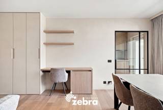 <strong>Het bezoekmoment gaat door op zaterdag 19 september 2026 (enkel op afspraak).</strong><br /><br />Luxueus gerenoveerd appartement in de groene en rustige residentie Ogierlande, waar comfort, kwaliteit en een verfijnde afwerking mooi samenkomen.<br /><br />Dit stijlvolle appartement (EPC-label B) combineert ruimte, natuurlijk licht en energiezuinig wonen met een hoogwaardige afwerking. Vanuit het zonnige terras geniet u van een aangenaam uitzicht op de zorgvuldig aangelegde gemeenschappelijke tuin, waar rust en groen centraal staan.<br /><br />Doorheen het appartement werd veel aandacht besteed aan materialen, details en een harmonieuze afwerking. De wanden en maatkasten werden uitgevoerd in een verfijnde Claystuc-techniek. De zachte textuur en natuurlijke kleurnuances geven het interieur een warme en rustige uitstraling.<br /><br />In de inkomhal zorgt een sensor voor de automatische sfeerverlichting, die discreet in de wand is geïntegreerd. Een verfijnd detail dat mooi aansluit bij de rustige uitstraling van het interieur. De lichtrijke leefruimte beschikt over een hoogwaardige parketvloer van Woodstoxx, stijlvolle maatkasten en een rechtstreekse toegang tot het zonnige terras.<br />De volledig geïnstalleerde keuken is uitgerust met kwalitatieve Siemens-toestellen en sluit mooi aan bij de uitstraling van de leefruimte. Aansluitend bevindt zich een praktische berging/wasruimte, voorzien van een waterontharder.<br />Verder beschikt het appartement over een afzonderlijk gastentoilet, twee ruime slaapkamers en een verzorgde badkamer met ligbad met douchefunctie en dubbele lavabo. Daarnaast is er een private kelderberging aanwezig.<br /><br />Ook op het vlak van comfort werd aan de nodige details gedacht. Aan de voorzijde zijn automatische rolluiken voorzien en aan de achterzijde zonnescreens. De temperatuur in het appartement kan bovendien vanop afstand worden geregeld.<br /><br />Een verzorgd en tijdloos appartement met een rustige uitstraling, kwalitatieve materialen en aandacht voor detail.<br /><br />Mogelijkheid tot aankoop van:<br />Ondergrondse garagebox met automatisch poort aan €30.000,-<br />Bovengrondse staanplaats bij te kopen aan €15.000,-<br /><br /><strong>Ook wild geworden van deze thuis?<br />Ontdek zelf de aangename sfeer, hoogwaardige afwerking en rustige ligging van dit appartement en plan vandaag nog uw bezoek.</strong>