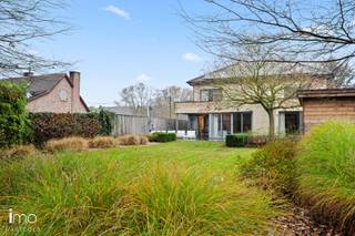 <blockquote>
<div>
<div>
<p><span>Cette villa prête à emménager combine style, confort et un sentiment d’espace exceptionnel. Au fil des années, la maison a été entretenue avec beaucoup de soin, toujours avec un souci de qualité et de choix durables. Grâce à l’installation récente d’une chaudière moderne, de panneaux solaires avec batterie domestique et d’une isolation supplémentaire de la toiture, vous bénéficiez ici d’un label énergétique A.</span></p>
<p><span>Le vaste hall d’entrée, équipé d’un vestiaire et d’un WC invités, vous mène vers le séjour. De larges baies vitrées assurent une belle luminosité et offrent une vue directe sur le jardin magnifiquement aménagé. La terrasse couverte s’y raccorde parfaitement, idéale pour en profiter toute l’année. Plus loin, on accède à la cuisine entièrement équipée, qui communique aisément avec le débarras et le double garage.</span></p>
<p><span>À l’avant se trouve un vaste bureau, parfait pour ceux qui souhaitent travailler à domicile.</span></p>
<p><span>À l’étage, vous trouverez la chambre parentale avec son propre dressing et sa salle de bains. S’y ajoutent deux autres grandes chambres ainsi qu’une deuxième salle de bains, équipée d’une douche, d’un double lavabo et d’un WC.</span></p>
<p><span>Le jardin est un véritable atout : joliment aménagé, entièrement privé et jouxtant une zone verte apaisante. Vous trouverez encore des espaces de stockage supplémentaires dans le vide sanitaire sous le garage et dans le vaste grenier. Enfin, à l’avant de la maison, il est possible de garer quatre voitures.</span></p>
</div>
</div>
</blockquote>