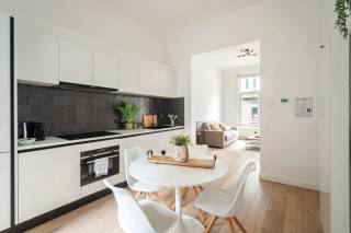 Gelegen in de Kroonstraat, tussen het bruisende Zurenborg en het gezellige Moorkensplein, bevindt zich dit trendy appartement op de gelijkvloerse verdieping van een kleinschalig gebouw. Op wandelafstand van zowel de Dageraadplaats als de Draakplaats geniet je hier van tal van leuke horecazaken en winkels, met bovendien vlotte verbindingen naar het centrum van Antwerpen. Een aangename en levendige omgeving waar jong en oud zich meteen thuis voelen.<br /><br />Bij het betreden van het appartement kom je binnen in een aangename, lichtrijke leefruimte waar grote raampartijen zorgen voor een open en ruimtelijk gevoel. Aansluitend bevindt zich de moderne open keuken, uitgerust met kwalitatieve inbouwtoestellen en voldoende werk- en opbergruimte, waardoor koken en gezellig samenzijn hier perfect hand in hand gaan. Vanuit de keuken heeft u bovendien rechtstreeks toegang tot de aangename buitenruimte, een absolute troef die het wooncomfort van dit appartement naar een hoger niveau tilt.<br /><br />Achteraan het appartement bevindt zich een ruime en rustige slaapkamer, voorzien van een ensuite badkamer met een comfortabele, ruime inloopdouche. Tot slot is er een praktische kelderberging aanwezig, die extra opslagruimte biedt.<br /><br />Kortom, een instapklaar en stijlvol appartement op een gegeerde locatie, waar comfort, ruimte en een bruisende buurt perfect samenkomen.<br /><br />Interesse?<br />Contacteer LISTED voor een bezoek: +32 3 283 51 51.