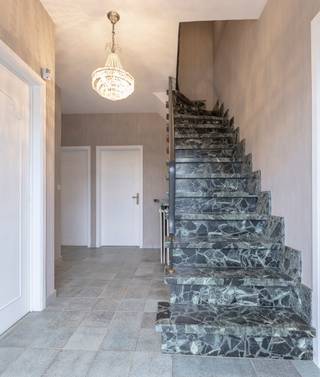 <p>Ontdek deze ruime, solide woning gelegen in een rustige, doodlopende straat, waar privacy en rust hand in hand gaan. De woning is licht te renoveren en biedt alle troeven om er een warme, eigentijdse gezinswoning van te maken.</p>
<p>Op het gelijkvloers kom je binnen via een ruime inkomhal met plaats voor vestiaire en een apart gastentoilet. De aangename leefruimte geniet van veel natuurlijke lichtinval en een gezellige open haard, perfect voor knusse avonden. De volledig ingerichte keuken biedt rechtstreekse toegang tot de tuin en het deels overdekte terras. Verder vind je op dit niveau ook een praktische bureauruimte (die eveneens kan dienen als extra slaapkamer), twee slaapkamers en een garage met werkput, ideaal voor de doe-het-zelver of autoliefhebber.</p>
<p>De eerste verdieping omvat een derde slaapkamer en twee ruime zolderkamers die eenvoudig kunnen worden ingericht als extra slaapkamers, hobbyruimtes of bureaus.</p>
<p>De kelderverdieping biedt extra bergruimte met twee ruime kelders, waarvan één momenteel is ingericht als wijnkelder. De andere kelder huisvest de verwarmingsketel.</p>
<p>De tuin omringt de woning en is bereikbaar via de garage, keuken en woonkamer. Het deels overdekte terras nodigt uit om te genieten van het buitenleven in alle seizoenen.</p>
<p>Daarnaast beschikt de woning over rolluiken en een alarmsysteem voor extra comfort en veiligheid. <br />Deze woning is ideaal voor wie op zoek is naar ruimte, rust en mogelijkheden om zijn eigen stempel te drukken op een degelijk gebouwde woning met karakter.</p>
<p><strong>EPC:</strong> 748 kWh/m²</p>
<p></p>