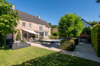 <p><strong>Exclusieve, luxueus afgewerkte villa op toplocatie nabij de Nederlandse grens</strong></p>
<p><strong>Deze uitzonderlijk ruime en perfect onderhouden villa (bouwjaar 2001) is gelegen op een prachtig perceel van ca. 1.383 m² en biedt een indrukwekkende bewoonbare oppervlakte van circa 474 m² (inhoud ca. 1.500 m³). De woning combineert comfort, luxe en privacy op hoog niveau en is ideaal voor wie ruim en stijlvol wil wonen in een groene, centrale omgeving.</strong></p>
<p><strong>De villa beschikt over onder andere 4 slaapkamers, royale leefruimtes, een stijlvolle woonkeuken met kookeiland, een dubbele inpandige garage én een grote zolder met uitbreidingsmogelijkheden. Bovendien is de woning uitgerust met een alarmsysteem en een centraal stofzuigersysteem, wat bijdraagt aan extra comfort en veiligheid. Energielabel: B.</strong></p>
<p>Gelijkvloers</p>
<p>Via de imposante inkomhal met gastentoilet betreedt u de woning. Hier ervaart u direct de ruimte en het hoogwaardige afwerkingsniveau. De sfeervolle woonkamer met gashaard vormt het warme hart van de woning en biedt een prachtig zicht op de tuin. Aansluitend bevindt zich een afsluitbare tv-kamer of bureau – ideaal voor thuiswerken of ontspanning.</p>
<p>De royale woonkeuken met kookeiland is voorzien van kwalitatieve inbouwapparatuur en vormt de perfecte plek voor gezellige momenten met familie en vrienden. Aan de achterzijde van de woning vindt u de praktische bijkeuken met aansluitingen voor wasapparatuur, een extra kantoorruimte en toegang tot de dubbele inpandige garage met automatische poorten.</p>
<p>Eerste verdieping</p>
<p>Op de eerste verdieping bevinden zich drie ruime slaapkamers. De indrukwekkende masterbedroom (ca. 45 m²) beschikt over een eigen inloopkast en aangrenzende dressing – een ware privé suite.</p>
<p>De luxe badkamer is compleet uitgerust met een dubbele wastafel met meubel, een ligbad en een comfortabele inloopdouche. Daarnaast is er op de overloop een separaat toilet aanwezig. Via een vaste trap bereikt u de tweede verdieping.</p>
<p>Tweede verdieping</p>
<p>De ruime zolderverdieping biedt tal van mogelijkheden en kan eenvoudig worden ingericht met extra (slaap)kamers, een hobbyruimte of fitnessruimte.</p>
<p>Buitenleven</p>
<p>De fraai aangelegde tuin biedt optimale privacy en is een waar verlengstuk van de woning. U geniet hier van meerdere terrassen en een sfeervolle overkapping met buitenhaard – perfect voor lange avonden in alle seizoenen. Aansluitend bevindt zich een praktische schuur.</p>
<p>Aan de voorzijde beschikt de woning over een verzorgde voortuin en een ruime oprit met parkeergelegenheid voor meerdere auto’s.</p>
<p>Kortom: een instapklare, luxueuze villa met uitzonderlijk veel ruimte, comfort en privacy op een uitstekende locatie. Een unieke kans voor wie exclusief wil wonen!</p>
<span>Bijzonderheden</span><br /><span>- EPC B</span><br /><span>- vloerverwarming<br /></span>- ruime kelder op stahoogte<br /><span>- centraal stofzuigersysteem</span><br /><span>- centrale ligging nabij scholen/winkels en Nederlandse grens</span><br /><span>- luxe afwerking</span>