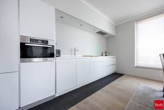 <strong>Stijlvol wonen aan het water – Kattendijkdok Westkaai 51 bus 3.4, Antwerpen</strong><br /><br />Welkom in dit prachtige appartement op een absolute toplocatie aan het bruisende Eilandje. Hier geniet u dagelijks van een uniek uitzicht op het Kattendijkdok, gecombineerd met de levendigheid van de stad, een uitstekende bereikbaarheid en een uitzonderlijke woonkwaliteit.<br /><br />Het gebouw werd ontworpen door de gerenommeerde Zwitserse architect Roger Diener en staat bekend om zijn tijdloze, minimalistische architectuur en hoogwaardige afwerking.<br /><br />Met een bewoonbare oppervlakte van ca. 100 m² biedt dit appartement een perfecte balans tussen ruimte, comfort en elegantie. De ruime leefruimte wordt gekenmerkt door grote raampartijen die zorgen voor een overvloed aan natuurlijk licht en een aangename connectie met de omgeving. Vanuit de leefruimte heeft u toegang tot het westgericht terras, waar u in alle rust kunt genieten van de middag- en avondzon. Het uitzicht combineert het beste van twee werelden: een zicht op het water enerzijds en een levendig stadszicht anderzijds.<br /><br />De open designkeuken is afgewerkt met kwaliteitsmaterialen en uitgerust met hoogwaardige Miele-toestellen, wat garant staat voor optimaal kookcomfort. De leefruimte werd bovendien voorzien van externe zonnewering, waardoor het appartement ook tijdens warme zomerdagen aangenaam blijft.<br /><br />Doorheen vrijwel het volledige appartement werd een kwalitatieve parketvloer doorgetrokken, wat zorgt voor een warme, stijlvolle en uniforme uitstraling. Enkel in de badkamer en het toilet werd gekozen voor een onderhoudsvriendelijke tegelvloer.<br /><br />Het appartement beschikt over twee ruime slaapkamers, een comfortabele badkamer, twee afzonderlijke toiletten en een praktische berging. Dankzij de doordachte indeling is dit appartement uitermate geschikt als gezinswoning, stijlvolle stadswoning of kwalitatieve investering.<br /><br /><strong>Extra troeven:</strong><br /><br />Westgericht terras<br />Zicht op zowel het water als de stad<br />Volledig doorgetrokken parketvloer<br />Hoogwaardige Miele-keukentoestellen<br />Externe zonnewering aan de leefruimte<br />Twee ruime slaapkamers<br />Topligging op het Eilandje<br />Nabij restaurants, musea, winkels en openbaar vervoer<br />Kelderberging en gemeenschappelijke fietsenberging<br />Energiezuinig en voorzien van hedendaags wooncomfort<br /><br />Ondergrondse parkeerplaats verplicht aan te kopen voor €40.000<br /><br />Een uitzonderlijk appartement op een van de meest gegeerde locaties van Antwerpen, waar architectuur, comfort en ligging naadloos samenkomen.<br /><br />Voor meer informatie of een bezoek ter plaatse kan u contact opnemen met Xander via 0497 18 10 84 of xander@reds.be.
