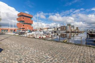 <strong>Unieke loft met zicht op het MAS en de jachthaven van Antwerpen</strong><br /><br />Op een gegeerde locatie, in Residentie Michiels-Loos, vindt u deze prachtige loft terug in een historisch gebouw. De loft – momenteel in gebruik als kantoor – bevindt zich op de eerste verdieping en is bereikbaar via een charmante binnentuin en ruime inkomhal met lift.<br /><br />De royale inkomhal van de loft zelf biedt een gastentoilet en vestiaire. Verder komt u in een indrukwekkende open ruimte met grote raampartijen die het licht en het uitzicht maximaal binnenhalen. De indeling omvat prachtig open ruimte voor een mooie living, luxueuze open keuken met alle toestellen, een polyvalente ruimte (ook geschikt als afgesloten tv-kamer of eetkamer) en een aparte slaapkamer met ingebouwde kasten.<br />De badkamer beschikt over een bad, douche en toilet. Afwerking met parketvloer en een geavanceerd alarmsysteem zorgen voor extra comfort en veiligheid.<br /><br />Extra:<br />- Dubbele cascade-autostaanplaats in de ondergrondse garage (apart bij te kopen aan 60.000 €)<br />- Momenteel verhuurd aan 2400 € (inclusief gem. kosten)<br />- Gemeenschappelijke kosten: Ca. € 170/maand<br /><br />Meer info of een bezoek?<br />Contacteer Sigalit via sigalit@reds.be of 0475/66.84.74.