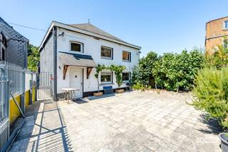 Op een steenworp van het stadscentrum van Dinant vindt u deze prachtige eengezinswoning, ideaal gelegen aan de oever van de Maas, in deze charmante en toeristische stad. U geniet er van een rustige en aangename omgeving, terwijl alle voorzieningen, winkels, scholen en diensten zich op een steenworp afstand bevinden.<br /><br />Met een oppervlakte van ongeveer 150 m² bestaat deze woning uit een grote binnenplaats van meer dan 100 m² en een ruime garage die plaats biedt aan twee voertuigen. Op het gelijkvloers wordt u verwelkomd door een riante leefruimte met een aangename zithoek en een eetkamer, evenals een volledig ingerichte keuken. Een wasruimte met toilet vervolledigt dit niveau.<br /><br />Op de verdieping brengt een prachtige trap u naar vier grote slaapkamers, allen voorzien van dubbel glas, en een badkamer. Een zolder maakt het geheel compleet en biedt extra bergruimte.<br /><br />Deze woning vormt een zeldzame opportuniteit, zowel voor een gezin dat op zoek is naar ruimte en rust als voor een jong koppel dat zich in een prettige omgeving wil vestigen. Ze biedt ook een mooie investeringsmogelijkheid in een zeer gewilde toeristische stad.<br /><br />