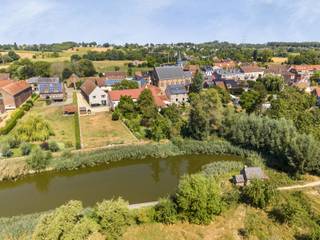 Immo Pické biedt u deze zeer ruime en bijzonder karaktervolle woning aan in Schepdaal (deelgemeente Dilbeek), grenzend aan het prachtig groene gebied rond de Pedemolen van Sint-Getrudis-Pede. De woning is prachtig landelijk gelegen, maar bevindt zich toch in de nabijheid van winkels, scholen, openbaar vervoer en invalswegen.<br /><br />Het oorspronkelijke gebouw dateert uit de jaren '90, werd volledig verbouwd in de jaren ’90 en werd in 2015 opnieuw volledig gerenoveerd.<br /><br />Op het gelijkvloers beschikt deze woning over een ruime inkomhal met gastentoilet, een eerste slaapkamer, een badkamer met douche en een zeer ruime leefruimte (48 m2) met open, volledig geïnstalleerde keuken (25 m2). Aansluitend is nog een grote ingerichte wasplaats, een ruime berging en een bijkomende stockageruimte.<br /><br />Ook op de eerste verdieping beschikt de woning over een indrukwekkende hoeveelheid ruimte. Hier bevindt zich de tweede slaapkamer (35 m²) incl. ensuite badkamer met ligbad, inloopdouche en dubbele lavabo. Naastliggend bevindt zich nog een derde slaapkamer (14 m²), een vierde slaapkamer (9 m²) en een toilet.<br /><br />Een bijzondere troef is daarnaast het ruime, afzonderlijke gedeelte op deze verdieping. Dit bestaat uit een tweede leefruimte (of vijfde slaapkamer) van 35 m², met aansluitend nog een zesde slaapkamer van 26 m² incl. badkamer met inloopdouche, lavabo en toilet. Achter deze slaapkamer vinden we nog een polyvalente ruimte van maar liefst 40 m² terug, perfect bruikbaar als dressing of hobbyruimte. <br /><br />Dankzij deze indeling kan dit gedeelte perfect dienstdoen als een eigen woonomgeving voor bijvoorbeeld inwonende ouders, met een afzonderlijke woonkamer, slaapkamer, badkamer en dressing. Tegelijk kunnen deze royale ruimtes eenvoudig als bijkomende slaapkamers of polyvalente kamers worden gebruikt, waardoor de woning ook uitermate geschikt is voor grote of samengestelde gezinnen.<br /><br />Daarnaast beschikt de woning nog over een ruime zolderverdieping die, mits het plaatsen van een vaste trap en verdere inrichting, nog bijkomende uitbreidingsmogelijkheden biedt.<br /><br />Daarnaast beschikt deze woning nog over een grote tuin achteraan. Ook kunnen er verschillende wagens geparkeerd worden, onder de carport en op de ruime oprit. <br /><br />Kortom, een uitzonderlijke eigendom voor wie op zoek is naar ruimte, karakter en flexibiliteit: ideaal voor een groot gezin, een samengesteld gezin of voor wie graag met meerdere generaties onder één dak woont, zonder daarbij aan privacy in te boeten.