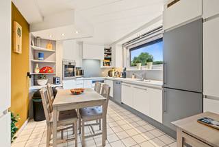 Deze ruime halfopen bebouwing met een bewoonbare oppervlakte van ca. 260 m² biedt bijzonder veel ruimte en mogelijkheden. Via de toegangspoort bereik je de grote oprit en dubbele garage, ideaal voor meerdere wagens en extra bergruimte.<br /><br />De inkomhal biedt rechts toegang tot de keuken en links tot een eerste leefruimte, een slaapkamer en een ensuite badkamer. Deze praktische indeling creëert heel wat mogelijkheden, zoals kangoeroewonen, comfortabel gelijkvloers wonen of de inrichting van een praktijk- of kantoorruimte voor een zelfstandig beroep.<br /><br />Verderop is er nog een apart toilet en een 2de, zeer ruime leefruimte met tal van mogelijkheden voor een gezellige zit- en eetruimte.<br /><br />Op de 1ste verdieping bevinden zich 2 slaapkamers, een grote badkamer en een praktische wasberging. De 2de verdieping beschikt over een zeer ruime zolderkamer, ideaal als 4de slaapkamer, bureau, hobby- of speelruimte.<br /><br />Buiten geniet je van een gezellige buitenruimte met overdekt loungegedeelte en achteraan een aangename groene omgeving.<br /><br />Een veelzijdige woning op een groene locatie met 4 slaapkamers, 2 badkamers, dubbele garage, veel parkeergelegenheid en ideaal voor een groot gezin, kangoeroewonen of een combinatie van wonen en werken.<br /><br />De naastgelegen bouwgrond kan optioneel mee aangekocht worden.<br /><br />Wij leiden je graag rond.