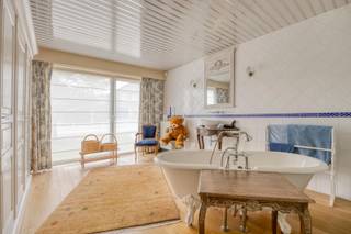 In een rustige, residentiële buurt van Hoeilaart, op wandelafstand van winkels, scholen en openbaar vervoer, presenteren wij dit instapklaar en energiezuinig gebouw met gemengd gebruik (bew. opp. 257 m²) op een perceel van 12a54ca. Grote raampartijen zorgen voor veel daglicht en een mooi zicht op de groene tuin.

Vrij beroep: deels ingericht met rechtstreekse toegang vanop straat, ideaal voor kapsalon/praktijk/kantoor/showroom. Voorzie ontvangstruimte, kantoor en sanitair (gebruik conform stedebouwkundige voorschriften).

Wonen: ruime leefruimte met open haard en eetkamer, aansluitend op een open én overdekt terras. Volledig ingerichte keuken met toegang tot het terras. Op het gelijkvloers: 2 grote slaapkamers, elk met eigen badkamer en dressing en-suite. Bovenverdieping: polyvalente ruimte als 3e slaapkamer met dressing en bureau.

Techniek &amp; energie: recente warmtepomp, 37 zonnepanelen, dakisolatie en hoogrendementsbeglazing (dubbel/deels driedubbel) → laag verbruik en hoog comfort.

Buiten &amp; praktisch: aangelegde tuin met tuinhuis; garage met automatische poort.

Contact: 02/731 07 07 — immo@home-consult.be