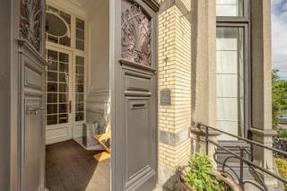 <p><span>BERCHEM - Cogels-Osylei</span><span>: Eclectische herenwoning “De Zwaluwen” met 6 slaapkamers, 3 badkamers, groot bureau, oprit en zuidtuin. </span></p><p><span> </span></p><p><span>Een uitzonderlijke opportuniteit voor liefhebbers van karaktervolle architectuur, erfgoed en stijlvol wonen in de stad. </span></p><p><span> </span></p><p><span>Gelegen aan de iconische Cogels-Osylei bevindt zich deze beschermde karaktervolle herenwoning uit 1904 naar ontwerp van architecten Cols en Defever. Een uniek stukje Antwerpse geschiedenis in het hart van de gegeerde historische wijk Zurenborg. De Cogels-Osylei geldt als het prestigieuze visitekaartje van de wijk en staat bekend om haar indrukwekkende eclectische architectuur, monumentale gevelrijen en uitzonderlijk goed bewaarde belle-époque uitstraling.</span></p><p><span>Wonen op de Cogels-Osylei betekent wonen in één van de mooiste straten van Antwerpen, op wandelafstand van station Berchem, hippe horecazaken, gezellige pleinen en alle stedelijke voorzieningen. De wijk combineert architecturale grandeur met een levendige, residentiële sfeer.</span></p><p><span> </span></p><p><span>BESCHRIJVING:</span></p><p><span> </span></p><p><span>Gelijkvloers</span><span>:</span></p><p><span>Voortuin met oprit en trappen naar het residentiële en professionele gedeelte.Inkomhal op marmer met vestiaire en gastentoilet. Toegang tot de zeer lichte en prachtige living met hoge plafonds en authentieke moulures en schouw. Aanpalende bibliotheek en formele eetplaats. Keuken met eethoek en via prachtige ramen toegang tot het terras en zuidgerichte tuin.</span></p><p><span> </span></p><p><span>Verdiepingen</span><span>: </span></p><p><span>Masterbedroom met open haard, aanpalende dressing met ingemaakte kasten en en-suite badkamer. Verder vinden we nog 5 ruime slaapkamers en 1 tot 2 badkamers.</span></p><p><span> </span></p><p><span>Kelder</span><span>:</span></p><p><span>Polyvalente open ruimte ingericht als kantoor voor vrij beroep in 3 verbonden bureauruimtes met directe toegang aan de straatkant, met op maat gemaakte kasten en bibliotheek en lavabo. Toegang tot terras via schuifdeuren.</span></p><p><span> </span></p><p><span>BIJZONDERHEDEN:</span></p><p><span> </span></p><p><span>*Unieke architectuur op historische toplocatie</span></p><p><span>*Enorm potentieel en behoud van karaktervolle elementen</span></p><p><span>*Mooie zuidgerichte tuin</span></p><p><span>*Oprit</span></p><p><span>*Ideale combinatie wonen/werken</span></p><p><span> </span></p>