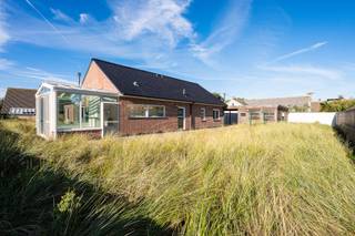 Algemeen<br />In het groene Middelkerke bevindt zich deze ruime en uitstekend onderhouden bungalow, gebouwd in 2011 en gelegen op een prachtig perceel van maar liefst 853 m². De woning werd met oog voor kwaliteit en comfort afgewerkt en beschikt onder meer over een centraal stofzuigsysteem, regenwaterrecuperatie, airconditioning en elektrische rolluiken. Dankzij de grote raampartijen en de tuin rondom de woning geniet je binnen van een overvloed aan natuurlijk licht en een aangenaam contact met de buitenruimte. In 2023 werd de leefruimte bovendien uitgebreid met een stijlvolle veranda, waardoor binnen en buiten nog mooier in elkaar overvloeien.<br /><br />Ook de ligging is een absolute troef. De woning bevindt zich vlak bij de Warandetoren, op wandelafstand van de kust en diverse voorzieningen. Zowel een bus- als tramhalte liggen in de nabije omgeving, waardoor je je ook zonder wagen gemakkelijk kunt verplaatsen. Hier geniet je van een fijne combinatie van rust, ruimte en comfort, op een boogscheut van zee.<br /><br />Indeling<br />Via de inkomhal bereik je de gezellige leefruimte, een afzonderlijk gastentoilet en een eerste slaapkamer, die momenteel als bureau is ingericht. De ruime leefruimte sluit naadloos aan op de volledig open keuken en de lichtrijke veranda, vanwaar je geniet van een prachtig zicht op de tuin. De spekkachel op aardgas zorgt bovendien voor extra warmte en gezelligheid tijdens de koudere maanden. Vanuit de keuken bereik je via de nachthal nog twee extra slaapkamers, een tweede afzonderlijk toilet en de badkamer met inloopdouche. Daarnaast beschikt de woning over een praktische voorraadberging en een technische berging met aansluitingen voor een wasmachine en droogkast.<br />De zolderverdieping van circa 70 m² biedt bovendien bijzonder veel extra bergruimte en eventuele uitbreidingsmogelijkheden.<br /><br />Ook buiten heeft deze woning heel wat te bieden. De ruime tuin rondom de woning vormt een heerlijke plek om te ontspannen. Het grote terras sluit rechtstreeks aan op de veranda en is ideaal om van het buitenleven te genieten. Verder zijn er een geïsoleerd tuinhuis en een dubbele carport aanwezig. De ruime oprit biedt bovendien plaats aan meerdere wagens, een bijzonder praktische meerwaarde op deze locatie nabij de kust.<br /><br />Troeven<br />* Kwalitatieve afwerking<br />* Lichtrijke woning met zonnige tuin <br />* Veel parkeergelegenheid en opbergmogelijkheden<br />* Op wandelafstand van de kust<br /><br />Interesse<br />Ben je op zoek naar een ruime, lichtrijke en uitstekend onderhouden bungalow met een prachtige tuin, vlak bij de kust? Dan is deze woning absoluut een bezoek waard! Neem gerust contact op met Tim voor meer informatie of om een bezoek in te plannen.<br />📞 0487 40 21 28<br />📧 tim@gentill.be