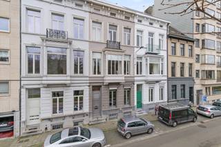 Dit statige herenhuis geniet van een uitzonderlijke ligging aan het Zuidpark in Gent en combineert authentieke charme met hedendaags comfort. De woning beschikt over een ruime kelder, een binnenplaats met parkeerplaats voor twee wagens, een recent geïnstalleerde elektrische laadpaal, zonnepanelen en een overdekt terras.<br /><br />Via de elektrisch bediende voordeur betreedt u de indrukwekkende inkomhal. Op het gelijkvloers bevindt zich een ruim bureau met aparte kantoorkeuken en afzonderlijk toilet. Deze verdieping leent zich perfect voor de uitoefening van een vrij beroep of praktijk aan huis. De kantoorkeuken biedt bovendien directe toegang tot de binnenplaats, de kelder en de bovenliggende verdiepingen via de statige trap.<br /><br />Op het tussenverdiep bevinden zich een ruime berging, vestiaire en een apart toilet.<br /><br />De eerste verdieping vormt het hart van de woning met een royale eetkamer, een tweede volledig uitgeruste keuken en een bijzonder ruim salon dat geniet van een adembenemend uitzicht over het Zuidpark.<br /><br />De tweede en derde verdieping herbergen samen vier volwaardige slaapkamers, een badkamer, een dressing en een afzonderlijk toilet. Op de vierde verdieping bevindt zich een ruime zolderverdieping met potentieel voor de inrichting van twee extra kamers en een bijkomende ruimte voorzien van een lavabo.<br /><br />Deze karaktervolle herenwoning werd oorspronkelijk gebouwd in 1863 en werd doorheen de jaren met zorg gerenoveerd, waarbij tal van authentieke elementen bewaard zijn gebleven. Het resultaat is een unieke eigendom met een uitzonderlijke uitstraling, royale volumes en tal van mogelijkheden voor zowel privégebruik als een combinatie van wonen en werken.