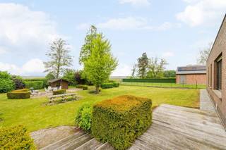 Op een royaal perceel van maar liefst 2.385 m² bevindt zich deze alleenstaande bungalow, gebouwd in 1975. De woning geniet van een rustige ligging op korte afstand van het centrum van De Madone, waar winkels, openbaar vervoer en een lagere school binnen handbereik zijn. Bovendien is er een vlotte verbinding naar Ieper, Staden en Houthulst.Deze degelijk gebouwde woning vormt de ideale basis voor wie op zoek is naar een renovatieproject met karakter. Dankzij de royale oppervlaktes, de grote raampartijen en de uitstekende constructie beschikt deze eigendom over alle troeven om uit te groeien tot een stijlvolle en comfortabele thuis.Bij het binnenkomen wordt u verwelkomd in een ruime inkomhal met vestiaireruimte en een gastentoilet. De lichtrijke leefruimte met houtcassette biedt een aangename woonbeleving en sluit naadloos aan op de veranda, waar u uitkijkt op het zonnige, zuidwestgerichte terras en de fraai aangelegde tuin. De keuken is functioneel ingericht met basisapparatuur en een composieten werkblad.Verder beschikt de woning over drie volwaardige slaapkamers, een badkamer uitgerust met zowel een ligbad als een douche, een lavabo en een tweede toilet. Tot slot is er een praktische wasplaats.De buitenruimte is zonder twijfel een van de grootste troeven van deze eigendom. De verzorgde tuin, de rust en de open verzichten zorgen voor een echt vakantiegevoel, elke dag opnieuw.Ook op technisch vlak biedt de woning interessante pluspunten, waaronder een droge kelder, een kruipkelder, centrale verwarming op mazout, een regenwaterput en een conforme elektrische installatie.Bent u op zoek naar een alleenstaande woning met een uitzonderlijk perceel, een rustige ligging én alle mogelijkheden om uw eigen woonproject te realiseren? Dan is deze eigendom absoluut een bezoek waard.EPC-label E – renovatieverplichting van toepassing.