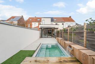 <p>High-quality, ideally located new-build home, stylishly finished in the centre of Waregem! <em>(subject to registration duties)</em></p>
<p><strong>Layout:</strong> entrance hall with cloakroom and separate toilet, bright living area opening onto the garden, open fully equipped kitchen (Dovy) with island, cold room, stair hall and cellar.<br />On the first floor you’ll find the landing, 2 full-sized bedrooms (one fitted out as a dressing room) and the bathroom.<br />The second floor offers 2 additional rooms and a storage area.</p>
<p>Fully landscaped, sun-oriented garden, swimming pool with sliding terrace and waterfall, plus a garden shed.</p>
<p><strong>HIGHLIGHTS:</strong></p>
<ul>
<li>
<p>Energy efficient: heat pump heating with cooling, solar panels</p>
</li>
<li>
<p>High-performance glazing with aluminium joinery</p>
</li>
<li>
<p>Luxurious, high-end finishes: bespoke designer cabinetry and lighting, sun screening with integrated lighting and Bluetooth speakers, full-height interior doors and windows, etc.</p>
</li>
<li>
<p>PRIME location in the heart of Waregem</p>
</li>
</ul>
<p>More info or a visit? Contact charlotte@immobeguin.be</p>