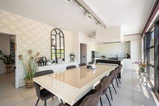 In Mol-Millegem bevindt zich deze uitzonderlijke, instapklare woning waar ruimte, comfort en luxe perfect samenkomen. De woning werd gebouwd in 2013 en biedt een bewoonbare oppervlakte van maar liefst 314 m² (bron EPC) op een prachtig perceel van 1.085 m². Met een EPC-score van 123 kWh/m² en een gunstig energielabel B geniet u hier van hedendaags en energiezuinig wooncomfort.<br /><br />Indeling gelijkvloers:<br />Via de inkomhal betreedt u de lichtrijke leefruimte, waar grote raampartijen zorgen voor een open en ruimtelijk gevoel. De kwaliteitsvolle leefkeuken vormt het hart van de woning en sluit naadloos aan op de gezellige tv-hoek en ruime eetplaats. De keuken is uitgerust met een koelkast, microgolfoven, oven, vaatwasser, inductiekookplaat en afzuigkap. Verder beschikt het gelijkvloers over een polyvalente ruimte die kan dienen als ontspanningsruimte of eetkamer, een gastentoilet, een berging en een ruime slaapkamer die eveneens perfect geschikt is als bureau of hobbyruimte.<br /><br />Eerste verdieping:<br />Via de nachthal bereikt u vier ruime slaapkamers, waaronder een bijzonder royale master bedroom met dressing. De badkamer is uitgerust met een douche en dubbele lavabo en biedt alle comfort voor het hele gezin. Daarnaast is er een apart toilet aanwezig.<br /><br />Buitenruimte:<br />De tuin vormt een absolute meerwaarde aan deze eigendom. Hier geniet u in alle rust van volledige privacy, zonder achterburen. Het ruime terras kan dankzij de overkapping als verlengstuk van de leefkeuken fungeren.<br /><br />Buitengewone kenmerken:<br />* Ruim perceel<br />* Zicht op groen<br />* Gunstig EPC<br />* Vijf slaapkamers<br />* Centrale locatie<br />* Regenwaterput 10.000l