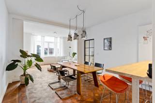 Dit ruim en lichtrijk appartement op de zesde verdieping met lift situeert zich in 'Berchem Palace', een prachtig gebouw uit 1937, dat vroeger dienstdeed als bioscoop en vandaag geklasseerd is als bouwkundig erfgoed. Het appartement straalt karakter uit dankzij originele elementen zoals de authentieke parketvloeren en tegelvloeren. Er werden recent ook enkele werken uitgevoerd, onder andere werd de achtergevel grondig geïsoleerd en vernieuwd, en zijn ook de terrassen en balustrades aangepakt.<br /><br />De ligging is een absolute troef: boven de galerij van Campo & Campo en op wandelafstand van het Albert- en Harmoniepark & brouwerij De Koninck. In de buurt treft u verder alle noodzakelijke voorzieningen. <br /><br />De inkomhal leidt naar de ruime leefruimte en eetkamer. Dankzij een open verbinding met een toog tussen de eetkamer en de volledig uitgeruste keuken met kookeiland, blijft het contact tussen de ruimtes behouden zonder dat je volledig afgesloten zit. Zo ervaar je een fijne én functionele doorstroming in het appartement. In de keuken is ook een aansluiting voor zowel wasmachine als droogkast aanwezig. <br /><br />Via de keuken loopt u door naar de nachthal. Van hieruit hebt u toegang tot de twee slaapkamers en badkamer met bad met douche. <br /><br />Verder beschikt het appartement ook over een terras, een berging en een ruime, droge kelderberging.<br /><br />Tot slot geniet u dankzij de ligging op de zesde verdieping van een prachtig uitzicht over de stad.<br /><br />Pluspunten<br />+ Uiterst goed gelegen<br />+ Uniek Art-Deco appartement in iconisch gebouw<br />+ Conforme elektrische keuring, Gunstig EPC<br />+ Lift<br />+ Terras<br /><br />Interesse? Neem contact met ons op via 03 337 50 70 of info@vbvastgoed.be.