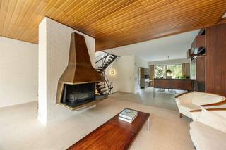 <p><span>Droom je van een woning met karakter én ruimte, waar architectuur, design en natuur samenkomen? Dan is deze unieke bel-etage aan de statige Collegelaan een buitenkans. De indrukwekkende leefruimte, authentieke sierelementen uit het laat modernisme, vier slaapkamers, een polyvalent gelijkvloers en de gezellige tuin maken van dit huis een echte blikvanger. En het Rivierenhof? Dat ligt letterlijk op het einde van de straat.</span><span> </span></p><p><span> </span></p><h3><span>Architectuur met een ziel</span></h3><p><span>Zodra je de woning binnenstapt, voel je dat dit geen doorsnee gezinswoning is. De ruime inkomhal met ingemaakte vestiairekasten geeft toegang tot de inpandige garage, een technische ruimte én een polyvalente ruimte die vandaag perfect dienst kan doen als hobbyruimte, praktijk, thuiswerkplek of zelfs kangoeroewoning. Dankzij de rechtstreekse verbinding met de tuin en de aanwezige sanitaire voorzieningen zijn de mogelijkheden hier eindeloos. </span></p><p><span>Via de iconische, stalen draaitrap — een architecturale eyecatcher die vandaag haast onbetaalbaar zou zijn om opnieuw te realiseren — bereik je de leefverdieping. Hier opent zich een indrukwekkende leefruimte van maar liefst ca. 70 m², waar grote raampartijen, hoge plafonds en de warme materiaalkeuze voor een uitzonderlijk gevoel van ruimte zorgen. De open haard vormt het sfeervolle middelpunt van de zithoek, terwijl de eetkamer naadloos overloopt in de keuken. Het maatwerkmeubilair en de originele architecturale details werden doorheen de jaren met veel zorg bewaard en geven de woning een tijdloze uitstraling.</span></p><p><span>De open keuken ademt dezelfde authentieke sfeer, maar werd tegelijk praktisch geüpdatet met kwalitatieve Miele-toestellen, waaronder een nieuwe oven, koelkast en vaatwasser. Vanuit de eetkamer stap je rechtstreeks het zonnige terras op, waar je uitkijkt over de groene tuin.</span></p><p><span> </span></p><h3><span>Vier slaapkamers en een zee van licht</span></h3><p><span>Op de tweede verdieping brengt de centrale overloop je naar vier slaapkamers, twee badkamers en een apart gastentoilet. Opnieuw speelt natuurlijk licht hier de hoofdrol dankzij de grote ronde lichtkoepel boven de hal.</span></p><p><span>De master bedroom beschikt over een ensuite badkamer met dubbele lavabo, ligbad en sfeervolle blauwe betegeling. Daarnaast zijn er nog twee ruime slaapkamers en een vierde kamer die perfect kan dienen als kinderkamer, bureau of dressing. Dankzij de grote ramen geniet elke kamer van veel licht en een mooi uitzicht op het omliggende groen.</span></p><p><span> </span></p><h3><span>Tuin vol privacy, midden in de stad</span></h3><p><span>Het terras sluit naadloos aan op de leefruimte en vormt de ideale plek voor een ontbijt in de ochtendzon of een gezellige barbecue met vrienden. Via de trap bereik je de fijne tuin, waar volwassen bomen, groen en volledige privacy zorgen voor een oase van rust. Kinderen hebben hier alle ruimte om te spelen, terwijl volwassenen genieten van het groene uitzicht.</span></p><p><span> </span></p><h3><span>Rivierenhof letterlijk om de hoek</span></h3><p><span>De ligging is zonder meer uitzonderlijk. Je woont op de statige Collegelaan, één van de meest gegeerde locaties van Borgerhout, met het Rivierenhof letterlijk op het einde van de straat. Wandelen, sporten of picknicken doe je in één van de mooiste parken van Antwerpen. Winkels, scholen, openbaar vervoer en een Velo-station bevinden zich allemaal op wandelafstand. Bovendien bereik je via de Ring of de autosnelweg in enkele minuten elke uithoek van de stad.</span></p><p><span> </span></p>