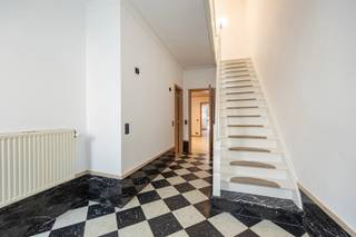 <p>Deze woning biedt volop mogelijkheden voor ruim en flexibel wonen. Ze is ideaal voor een groot gezin, een samengesteld gezin of als kangoeroewoning. Achter de gevel schuilt maar liefst 235 m² bewoonbare oppervlakte, met vier slaapkamers, een aangename tuin, een achteruitweg en een energiezuinig karakter dankzij het gunstige B-label.</p>
<p><strong>Gelijkvloers (102m²)</strong><br />Op het gelijkvloers bevinden zich een ruime inkomhal (8m²), een garage (24m²) met extra bergruimte en een droge kelder (6m²). De leefruimte (20m²) sluit aan op de keuken met open eetplaats (33m²). Naast de keuken is er een eerste berging, daarnaast zijn er een apart toilet en een berging/wasplaats (9m²). De fijne tuin ligt te midden van het groen en biedt een aangename buitenruimte.</p>
<p><strong>Eerste verdieping (66m²)</strong><br />Op de eerste verdieping bevindt zich een bijkomende leefruimte (37m²) met een aparte tweede keuken (7,5m²). Deze ruimte kan ook perfect dienstdoen als polyvalente ruimte. De badkamer is ingericht met een ligbad en toilet (7,5m²).</p>
<p><strong>Tweede verdieping (54m²)</strong><br />De tweede verdieping beschikt over vier slaapkamers (12-11-9-7m²). Via een trektrap is er toegang tot de zolder (13m²).</p>
<p><strong>Extra troeven</strong><br />De woning wordt verwarmd op aardgas. In 2022 werden de ramen en de verwarming vernieuwd. Daarnaast zijn de daken geïsoleerd, wat bijdraagt aan het energiezuinige karakter van de woning.</p>