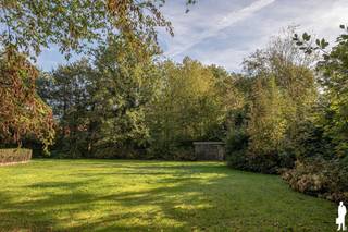 In de gegeerde wijk <strong>Schotenhof </strong>ligt deze unieke <strong>villa</strong>, omringd door groen, nabij scholen, sportclubs en op fietsafstand van twee dorpscentra.<br />De <strong>tuin </strong>ligt zonovergoten op het <strong>zuiden</strong>, zonder inkijk. De voortuin met haar gezellige waterpartij is riant, en kent een prachtig eiken <strong>bijgebouw</strong>, met verwarming en opbergplaats.<br /><br /><strong>INDELING</strong><br />Via enkele treden kom je via een zeer brede inkomdeur in een riante inkomhal. De dubbele glazen deur geeft meteen verbinding met de leefruimte, waar dezelfde mooie natuurstenen vloer doorloopt. Het verhoogde zitgedeelte kent een gezellige open haard. Voorts is er nog een eetgedeelte met toegang tot de keuken. Langs voor- en achterzijde voel je de verbinding met de groene tuin.<br />Aansluitend is de keuken met het hart van de woning, de AGA, en een gezellig eiland met eetgelegenheid. Miele ovens. Het houten werkblad dient opgefrist te worden. De glazen deurtoegang naar het terras en de tuin is heerlijk . Een bureau of polyvalente kamer met eveneens toegang tot het terras en vervolgens een praktische ruime bijkeuken. <br />De dubbele <strong>inpandige garage </strong>biedt niet alleen plaats voor twee auto’s, maar zorgt ook voor extra opbergruimte.<br /><br /><strong>Eerste verdieping</strong><br />De nachthal geeft toegang tot de hoofdslaapkamer, een badkamer en nog drie bijkomende slaapkamers met tal van ingemaakte kasten met een tweede badkamer.<br /><br />Een tweede trap biedt toegang tot een riante kamer met mezzanine en nog eens toegang tot een zolder. <br />Volop ruimte, nog in te delen naar believen.<br />Een kelder met bijzonder veel ruimte.<br /><br />De prachtig aangelegde tuin heeft een ideale <strong>zuid-oriëntatie</strong>, waardoor u hier vanaf de vroege ochtend tot laat in de middag volop van de zon geniet. Een waar paradijs in alle privacy en rust.<br /><br /><strong>Bijzonderheden</strong><br />* Toplocatie: Residentieel en groen gelegen in Schotenhof, vlakbij ’s Gravenwezel, én Schoten, diverse scholen én sportfaciliteiten met ondermeer gerenommeerde tennisclub.<br />* Ruimte & potentieel: Familiewoning met 5 slaapkamers en 2 badkamers.<br />* Buitenleven: Prachtig zonnige tuin met optimale privacy en riant eiken bijgebouw.<br />* Praktisch: Inpandige dubbele garage, én een extra garage én riante voortuin. Comfortabele bijkeuken en opbergzolder. <br /><br />Een unieke gelegenheid.