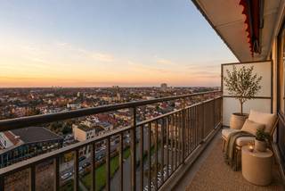 Dit smaakvol vernieuwde appartement is gelegen aan het Sporthalplein 148, op de 10de verdieping, en geniet van prachtige open zichten. Dankzij de terrassen aan zowel de voor- als achterzijde kan u op elk moment van de dag genieten van zon en uitzicht.<br /><br />Het appartement werd grondig gerenoveerd met onder meer nieuwe ramen, vernieuwde sanitaire afvoeren, een volledig nieuwe elektriciteit die conform is voor de komende 25 jaar, en een kwalitatieve afwerking doorheen het hele appartement.<br /><br />De indeling omvat een inkomhal met beveiligde deur, een apart gastentoilet, een moderne badkamer met inloopdouche en een lichtrijke leefruimte. De nieuwe, moderne keuken geeft rechtstreeks toegang tot het terras en biedt een aangename verbinding met buiten. Aansluitend bevindt zich een praktische berging, ideaal voor onder andere wasmachine en droogkast. Verder zijn er twee ruime slaapkamers, geschikt voor dubbele bedden.<br /><br />Daarnaast genieten bewoners van gemeenschappelijke autostaanplaatsen vlak voor de deur, exclusief voor de residentie, wat zorgt voor extra comfort. Een privatieve berging op niveau -2 is inbegrepen, ideaal voor bijkomende opslagruimte.<br /><br />Dankzij de nieuwe ramen behaalt het appartement een gunstige EPC-score met label B.<br /><br />Ideaal als investering of als comfortabele eigen woonst.