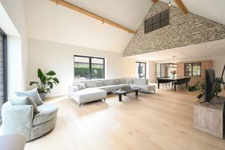 Deze woning van ca. 411 m² bevindt zich op een aantrekkelijke locatie op wandelafstand van de dorpskern van Vosselare. Ze werd volledig geïsoleerd en uitgerust met een lucht/waterwarmtepomp in combinatie met een zonneboiler voor vloerverwarming en warm water. 30 zonnepanelen ondersteunen een duurzaam energieverbruik, terwijl een lucht/luchtwarmtepomp zorgt voor comfortabele koeling in de slaapkamers. Op het gelijkvloers vindt u een inkomhal met gastentoilet en bureauruimte, een leefruimte met open nok die het gevoel van ruimte versterkt, en een volledig uitgeruste keuken met inbouwtoestellen en plaats voor een eetruimte. De keuken sluit aan op een praktische berging, terwijl een tweede inkom toegang biedt tot de was- en strijkruimte. Verder zijn er drie volwaardige slaapkamers, waaronder één met dressing, en een quasi volledig afgewerkte badkamer met dubbele lavabo, ligbad, inloopdouche en toilet. De eerste verdieping biedt twee grote slaapkamers en een vide, ideaal voor een bureau, hobbyruimte of extra leefruimte. De tweede badkamer is voorbereid voor verdere afwerking en er is een apart tweede toilet aanwezig. De tuin beschikt over zonneterrassen, een zwemvijver en een oprit met meerdere plaatsen. <br />​​​​​​<br />EPC: 66kWh (A) / elektriciteit: Conform / CV warmtepomp/ asbestveilig<br /> 