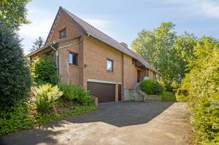 Deze tijdloze en uitstekend onderhouden villa is bereikbaar via een statige oprijlaan en bevindt zich op een prachtig perceel van ca. 22 are.<br />De villa is gelegen in een residentiële en groene woonomgeving die recent werd ingericht als woonerf met bijzondere aandacht voor rust, natuur en leefkwaliteit.<br />Bij het betreden van de woning komt u terecht in een ruime inkomhal met gastentoilet. Het gelijkvloers biedt verder een royale bureauruimte, een aangename eetplaats die naadloos overgaat in de gezellige zithoek met inbouwhaard, en een ruime keuken met ontbijthoek. Daarnaast beschikt de woning over een praktische wasplaats/berging én een volwaardige slaapkamer met ensuite badkamer, ideaal voor gelijkvloers wonen of gastenverblijf.<br />Op de verdieping bevinden zich vier ruime slaapkamers, een badkamer uitgerust met dubbel lavabomeubel en douche, een apart toilet en een grote open ruimte die perfect dienst kan doen als hobbyruimte, speelkamer of extra bureau.<br />De woning is volledig onderkelderd en beschikt over een dubbele garage, een atelier, een CV-kelder en een ruime voorraadkelder.<br />De prachtig aangelegde tuin vormt een ware oase van rust en privacy. Natuurliefhebbers zullen hier volledig tot rust komen, terwijl u tegelijk geniet van een uitstekende ligging op fietsafstand van Leuven.<br />Een unieke eigendom voor wie op zoek is naar ruimte, privacy, comfort en een groene omgeving nabij de stad.<br /> 
