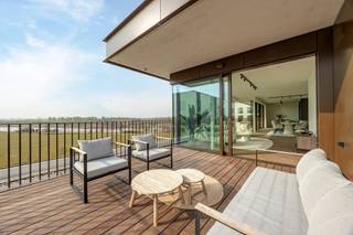 Dit uitzonderlijke dakappartement verwelkomt u via een stijlvolle inkomhal, voorzien van een gastentoilet en een praktische berging/wasplaats...