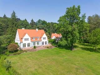 <p><span>Dit bijzondere eigendom is gelegen op een zeer rustige en groene locatie te Kapellen nabij Royal Antwerp Golf Club. Rust, een groene omgeving alsook een goede verbinding met het centrum van Heide-Kalmthout zijn troeven van deze locatie. Het domein van ruim 1 hectare groot omvat een recent gerenoveerde villa, een guesthouse, garage gebouw, zwembad en tennis terrein.</span></p><p><span> </span></p><p><span>Hoofdgebouw</span></p><p><span>U betreedt de villa middels de centrale inkomhal op parketvloer met trap naar de eerste verdieping alsook vestiaire, gastentoilet en toegang tot de kantoorruimte. De leefruimte werd opgedeeld in een zitkamer met open haard, aangename eetruimte en een tv-kamer. Deze drie ruimtes kunnen worden afgesloten middels schuifdeuren. Smaakvol ingerichte keuken met diverse inbouwtoestellen waaronder vaatwasser, koelkast, oven, gasvuur en dubbele spoelbak. Vanuit de keuken toegang tot de bijkeuken met kasten en toegang naar de kelderruimte. </span></p><p><span><br />1e Verdieping</span></p><p><span>Middels de trap bereikt u ruime nachthal met loungeruimte. De masterslaapkamer omvat een ruime dressing met ingemaakte kasten alsook een badkamer met bidet, toilet, douche, ligbad en dubbele lavabo. Tweede ruime slaapkamer met dressing en privatieve badkamer met ligbad, toilet en lavabo. Derde slaapkamer met lavabo, separate badkamer en een vierde slaapkamer met ingemaakte kasten. </span></p><p><span> </span></p><p><span>2e Verdieping / zolder</span></p><p><span>Toegang naar de zolderruimte middels vlieringtrap. De zolderruimte is opgedeeld in drie compartimenten. </span></p><p><span> </span></p><p><span>Kelder</span></p><p><span>De kelderruimte werd ingedeeld in verschillende ruimtes waaronder een wijnkelder, berging en een wasplaats met strijkgedeelte met aansluitingen voor wasmachine en droogkast. Tevens is er een speelkamer of polyvalente ruimte en een relaxgedeelte of wellness met tevens toegang naar buiten toe (nota; deze ruimtes zijn nog niet gerenoveerd). Apart technisch lokaal met CV installaties (condenserende gasketels Buderus) alsook waterontharder. </span></p><p><span> </span></p><p><span>Guesthouse en polyvalent gebouw</span></p><p><span>Op het domein is een apart guesthouse in dezelfde stijl als het hoofdgebouw met 2 slaapkamers, 2 badkamers, een keuken en 2 garages. Een derde gebouw is polyvalent te gebruiken en bestaat uit een grote kantoorruimte en 2 extra garages.</span></p><p><span> </span></p><p><span>Bijzonderheden</span></p><p><span>Dit domein op ruim 1 hectare grond werd gerealiseerd in de jaren '50 en in 2022 werd de villa volledig gerenoveerd naar hedendaagse normen van luxe, comfort en afwerking. De villa heeft hiermee ook een EPC label B (172 KWH). </span></p><p><span>De tuin werd ook deels opnieuw aangelegd en hier treft u behalve een zwembad ook een tennis terrein. </span></p><p><span> </span></p><p><span>Meer inlichtingen via ons kantoor</span></p>