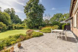 <p><span><span>Karaktervolle landelijke woning met 4 slaapkamers en ruime tuin te Rijmenam (Bonheiden).</span></span><br /><br /><span><span>De woning werd gebouwd in 1978, geïnspireerd door de authentieke Brabants-Kempische hoevestijl en met bijzondere aandacht voor traditioneel vakmanschap en materialen. </span></span></p><p><span><span> </span></span></p><p><span><span>Het genuanceerde metselwerk, het imposante pannendak, de houten luiken, zichtbare balkstructuren, terracottavloeren en de monumentale open haard geven de woning de warme uitstraling van een historische hoeve. Het gebruik van recuperatiematerialen zoals de houten balken en de binnendeuren benadrukken de authenticiteit die bij de bouw van deze woning werd nagestreefd. </span></span></p><p><span><span> </span></span></p><p><span><span>Op het gelijkvloers geeft de inkomhal, met gastentoilet en imposante trap naar de verdieping, toegang tot de royale, lichtrijke leefruimte met gezellige zit- en eethoek. De opkamer links van de eetkamer is momenteel ingericht als gerieflijk thuiskantoor, terwijl aan de rechterkant een keuken met de nog originele inrichting voldoende ruimte biedt voor een gezellige ontbijthoek. Aanpalend aan de keuken bevindt zich de achterinkom met toegang tot de tuin én tot een grote open ruimte waarin de wasplaats, de garage voor 2 wagens en de technische installaties zijn ondergebracht. Voor de autoliefhebbers is in de garage een smeerput aanwezig.</span></span></p><p><span><span> </span></span></p><p><span><span>Op de verdieping bevinden zich 4 ruime slaapkamers waarvan één werd ingericht als atelier. Dit atelier kan opgesplitst worden in twee afzonderlijke slaapkamers, wat deze woning ideaal maakt voor grote gezinnen. Verder vind je op deze verdieping nog een ruime badkamer met ligbad en een afzonderlijke douchekamer. In de nachthal geeft een luik met uitklapbare trap toegang tot de bergzolder, dewelke zich over de volledige breedte van de woning uitstrekt.</span></span></p><p><span><span> </span></span></p><p><span><span>Buiten is het volop genieten in de zuidwest gerichte, mooi aangelegde tuin of op het zonnige terras met zonneluifel.</span></span></p><p><span><span> </span></span></p><p><span><span>De woning is rustig gelegen in een aangename residentiële en groene omgeving, met een landelijk karakter. Bonheiden, Putte en Mechelen zijn van hieruit vlot bereikbaar. Winkels, scholen en dagelijkse voorzieningen bevinden zich op korte afstand, terwijl de omliggende natuurgebieden en landelijke wegen tal van wandel- en fietsmogelijkheden bieden.</span></span></p><p><span><span> </span></span></p><p><span><span>Ben je op zoek naar een rustig gelegen, karaktervolle, rustieke woning, dan is dit misschien wel iets voor jou!</span></span><br /><span><span>Interesse? Contacteer ons via 0479/01.01.01!</span></span></p>