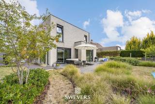 Voor meer info en foto’s, surf naar www.swevers.be – In het hart van Leopoldsburg, in een rustige en kindvriendelijke wijk, vind je deze instapklare open bebouwing uit 2017. De woning ligt op een zuidgericht perceel van 9a 31ca en biedt met 225 m² bewoonbare oppervlakte alle ruimte voor een gezin of thuiswerkend koppel. Op het gelijkvloers zorgen de lichtrijke zithoek, eetkamer en moderne keuken met kookeiland voor een open en aangename leefruimte van bijna 60 m². Een aparte bureau, berging, en gastentoilet maken het plaatje compleet. Boven bevinden zich drie ruime slaapkamers, waaronder een master met dressing, en een stijlvolle badkamer met bad, dubbele wastafel en toilet. Dankzij zonnepanelen, ventilatiesysteem en regenwaterrecuperatie woon je hier energiezuinig en comfortabel. De tuin is onderhoudsvriendelijk met automatisch besproeiingssysteem en biedt veel zonlicht, ook binnen. De ligging is top: winkels, scholen en openbaar vervoer zijn vlakbij. Deze moderne woning biedt rust, ruimte en praktisch comfort op een centrale locatie. Voor meer informatie, bel 011 255 155. Bron bewoonbare oppervlakte: EPC – verslag.