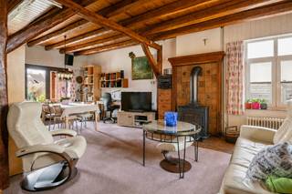 Centraal gelegen in Kalmthout, vinden we deze karakteristieke halfopen woning met veel renovatiepotentieel.<br /><br />We betreden de woning via de inkomhal, welke is voorzien van een gastentoilet.<br />De gezellige leefruimte is ingedeeld in een zithoek en een eetkamer. Aansluitend vinden we de keuken die is ingericht met een keramische kookplaat, koelkast en een dubbele spoelbak.<br />Via de hal is er toegang tot een ruime slaapkamer, een tweede slaapkamer (momenteel ingericht als dressing) en een badkamer die is voorzien van een inloopdouche, lavabo en een toilet.<br />Achteraan de woning bevindt zich een verwarmde veranda. Van hieruit komen we in de garage met automatische toegangspoort. Hier vinden we tevens de zekeringenkast van de elektriciteit en de vernieuwde verwarmingsketel (2022).<br /><br />De voormalige zolderverdieping werd afgewerkt en is ingedeeld in twee ruime slaapkamers, beide voorzien van een wastafel. De dakvlakramen werden vernieuwd.<br />Verder treffen we langs beide kanten van het dak een zolder die dient als bergruimte.<br />De warmwaterboiler bevindt zich op deze verdieping.<br /><br />De woning is gebouwd op een mooi perceel en heeft een open en zonnige tuin.<br /><br />Deze woning is gelegen vlakbij het centrum van Kalmthout. Alle voorzieningen zoals winkels, scholen en openbaar vervoer bevinden zich op wandel- en fietsafstand.