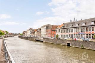 Ideaal gelegen langs de Schelde geniet dit gemengd gebouw van een bevoorrechte ligging met een panoramisch uitzicht op de rivier en een vlotte toegang tot de belangrijkste invalswegen van Doornik. In de onmiddellijke nabijheid van winkels, parkings, restaurants, scholen en openbaar vervoer biedt dit pand een uitstekende zichtbaarheid en een frequente passage, zowel te voet als met de wagen. Het gelijkvloers bestaat uit een ruime handelsruimte met etalage die rechtstreeks uitgeeft op de kaai, kantoren, een opslagruimte en een aangename kleine buitenkoer, ideaal om even te genieten van een ontspannend moment. Op de eerste verdieping ontdekt u een lichtrijke leefruimte met een prachtig uitzicht op de Schelde, een uitgeruste keuken, een badkamer en een douche. De tweede verdieping biedt eveneens een lichtrijke leefruimte met zicht op de rivier, twee slaapkamers, een uitgeruste keuken en een douchekamer. Het pand beschikt ook over een grote kelder. Dankzij zijn uitzonderlijke ligging, sterke zichtbaarheid en configuratie die handel en wonen combineert, vormt dit gebouw een mooie opportuniteit voor een professionele activiteit, een investeringsproject of een gemengd gebruik. Een zeldzaam pand aan de oever van de Schelde, dat een strategische ligging, commercieel potentieel en een aangename leefomgeving combineert. Voor een bezoek, contacteer Loïc: loicvddv@immobeguin.be