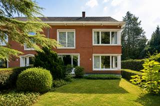 <p><strong>Zeer ruime hoekwoning op den Heuvel met 4 slaapkamers, praktijkruimte en mogelijkheden voor kangoeroewonen</strong></p>
<p>Deze <strong>bijzonder ruime hoekwoning</strong> onderscheidt zich door haar royale woonvolume en veelzijdige indeling. Met <strong>4 volwaardige slaapkamers, 2 badkamers, 2 keukens en meerdere leefruimtes</strong> biedt de woning uitzonderlijk veel mogelijkheden voor een groot of samengesteld gezin. Een extra kamer op het gelijkvloers kan bovendien perfect dienstdoen als <strong>bureau, praktijkruimte of 5e slaapkamer</strong>. De indeling van de eerste verdieping maakt ook <strong>kangoeroewonen of wonen met inwonende familie</strong> mogelijk. Buiten beschikt de woning over een volledig omheinde tuin, overdekt terras, ruime oprit en een grote vrijstaande garage.</p>
<p><strong>Gelijkvloerse verdieping<br /></strong>-<strong>Royale inkomhal</strong> <br />-Ruime en lichtrijke <strong>leef- en eetkamer</strong> met houtgestookte open haard<br />-Grote raampartijen zorgen voor veel natuurlijk licht<br />-Afzonderlijke <strong>bureau-/praktijkruimte</strong>, eveneens geschikt als speelkamer, hobbyruimte of 5e slaapkamer<br />-Keuken met keramische kookplaat, dampkap en koelkast<br />-Rechtstreekse toegang vanuit de keuken tot het <strong>overdekte terras en de tuin<br /></strong>-Aansluitende <strong>berging/wasplaats<br /></strong>-Badkamer met <strong>inloopdouche en lavabomeubel<br /></strong>-Apart gastentoilet<br />-Toegang tot de <strong>kelder</strong></p>
<p><strong>Eerste verdieping<br /></strong>-<strong>2 ruime slaapkamers<br /></strong>-Tweede badkamer met douche, lavabomeubel en toilet<br />-<strong>Tweede keuken</strong> met kookfornuis en dampkap<br />-Aansluitende, ruime <strong>leef- en eetkamer<br /></strong>-Dankzij de combinatie van een eigen keuken, leefruimte, slaapkamers en badkamer is deze verdieping bijzonder interessant voor <strong>kangoeroewonen, inwonende familie of een samengesteld gezin</strong></p>
<p><strong>Tweede verdieping<br /></strong>-<strong>2 bijkomende slaapkamers<br /></strong>-2 praktische bergruimtes<br />-Afgesloten traphal<br />-Extra <strong>bergzolder</strong> bereikbaar via een vlizotrap</p>
<p><strong>Tuin en buitenruimte<br /></strong>-<strong>Volledig omheinde tuin<br /></strong>-Ruim <strong>overdekt terras</strong>, rechtstreeks aansluitend op de woning<br />-Grote oprit met <strong>parkeermogelijkheid voor meerdere wagens<br /></strong>-Royale <strong>vrijstaande garage</strong> achteraan op het perceel<br />-Garage voorzien van een <strong>smeerput</strong> en veel bijkomende opslag- en werkruimte</p>
<p><strong>Bijzonderheden<br /></strong>-<strong>4 volwaardige slaapkamers <br /></strong>-<strong>2 badkamers<br /></strong>-<strong>2 keukens en meerdere leefruimtes<br /></strong>-Uitstekende mogelijkheden voor <strong>kangoeroewonen<br /></strong>-Ideaal voor <strong>praktijk aan huis, vrij beroep of thuiswerk<br /></strong>-Veel woonruimte verdeeld over 3 verdiepingen<br />-Kelder en kruipruimte<br />-Recente verwarmingsketel op aardgas<br />-Rolluiken en vliegenramen<br />-Volledig omheind perceel<br />-<strong>Grote vrijstaande garage<br /></strong>-Ruime parkeermogelijkheden op eigen terrein</p>
<p><strong>Ligging<br /></strong>Gelegen <strong>in Kalmthout</strong>, in een aangename woonomgeving op korte afstand van het centrum en de Kalmthoutse heide.<br />Winkels, scholen, openbaar vervoer en dagelijkse voorzieningen zijn vlot bereikbaar. Dankzij de centrale ligging geniet u bovendien van een goede verbinding met de omliggende gemeenten.</p>
<p><strong>Een uitzonderlijk ruime en veelzijdige woning voor wie vooral veel woonruimte en flexibiliteit zoekt. Ideaal voor een groot of samengesteld gezin, kangoeroewonen of de combinatie van wonen en werken onder één dak.<br /><br /></strong>Bewoonbare opp. 287 m² ref.: bruto vloeropp. EPC-certificaat.</p>
<p><strong> </strong></p>
