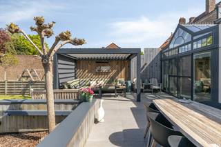 Verrassend ruim huis (EPC A: 76, 226m² bewoonbare oppervlakte) met 5 slaapkamers (mogelijkheid tot gelijkvloers wonen), afzonderlijke praktijkruimte op het gelijkvloers, privatieve oprit met plaats voor enkele wagens, lichtrijke woonkamer, aangelegde tuin (533m²) met tal van terrasoppervlakte + kwalitatief bijgebouw. Dit instapklaar en uitermate goed onderhouden huis te koop geniet van een centrale ligging langs de Toekomststraat, nabij het centrum van Sint-Kruis, openbaar vervoer, buurtwinkels, warenhuizen, scholen, sportcentra en met een vlotte verbinding naar Brugge, Damme, Knokke, Maldegem... Tevens beschikt dit huis over een conforme elektrische keuring, 18 zonnepanelen, rolluiken...Indeling:Gelijkvloers (circa 140m²):- Ruime inkomhal (12m²) met gastentoilet en toegankelijke trap;- afzonderlijke, polyvalente praktijkruimte (35m²);- lichtrijke woonkamer (55m²) met compleet uitgeruste leefkeuken;- gezellige veranda (18m²);- praktische, ruime garage (21m²);- aangelegde tuin (533m²) met tal van terrasoppervlakte + kwalitatief bijgebouw + privatieve oprit met plaats voor enkele wagens.1ste verdieping (circa 86m²):- Nachthal (10m²);- 5 slaapkamer (17m², 12m², 10m², 9m², 8m²);- badkamer (14m²) voorzien van dubbele lavabo in meubel, douche, ligbad, toilet.Bestuursmaatregelen in het maatregelenregister: nee