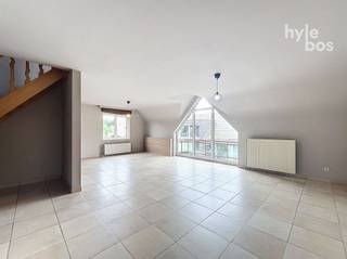 <p><span>Dit rustig gelegen duplexappartement verrast meteen door zijn uitzonderlijke ruimte. De royale leefruimte geniet dankzij de grote raampartijen van veel natuurlijk licht en geeft uit op een aangenaam terras. De afzonderlijke leefkeuken is uitgerust met een elektrisch kookvuur en dampkap. Daarnaast is er een ruime berging met aansluitingen voor wasmachine en droogkast. Op deze verdieping bevinden zich ook de badkamer met ligbad en lavabo en een afzonderlijk toilet. De bovenverdieping biedt twee ruime slaapkamers en een tweede afzonderlijk toilet. Via de oprit naast het gebouw bereikt u de individuele garage.</span></p><p><span> </span></p>