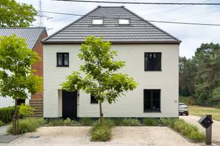 Ruim wonen, vlot bereikbaar zijn én binnen enkele minuten tussen de bossen staan? Aan de Kiezelweg in Mol hoef je gelukkig niet te kiezen.<br /><br />Deze vrijstaande woning werd in 2021 van A tot Z gerenoveerd door een aannemer en kreeg een frisse, strak-klassieke uitstraling. Vooraan zorgen de wit geschilderde gevel, zwarte ramen en aangelegde voortuin voor een verzorgde eerste indruk. Parkeren kan op de twee aangelegde plaatsen én op de ruime oprit, waar minstens zes wagens terechtkunnen.<br /><br />Binnen kom je via de ruime inkomhal, waar de technieken netjes achter kastdeuren verdwenen zijn. Verder vind je hier een gastentoilet en toegang tot de open leefruimte.<br /><br />En die leefruimte is meteen het hart van de woning. Wonen, eten en koken vloeien hier mooi in elkaar over, met zachte tinten, warme houtaccenten en grote raampartijen op een zuidgerichte tuin.<br /><br />De keuken is volledig uitgerust met een inductiekookplaat, spoelbak, koelkast, vaatwasser, oven en microgolfoven. Het ruime kookeiland biedt vier zitplaatsen.<br /><br />Aansluitend ligt de praktische berging en wasruimte met een aparte achterinkom. Op het gelijkvloers bevindt zich ook een ruime badkamer met ligbad, douche en twee lavabo’s.<br />De eerste verdieping telt een grote master bedroom met ingerichte maatwerkdressing, een ruime kinderkamer, een tweede badkamer met douche en dubbele wastafel, en een apart toilet. Nog een verdieping hoger bereik je via de vaste trap een volledig afgewerkte, open zolderruimte.<br /><br />Buiten beschik je over een perceel van in totaal maar liefst 31,5 are. De voortuin en parkeerzones zijn al aangelegd; de grote achtertuin kan nog volledig naar eigen smaak worden ingericht.<br /><br />Ook technisch staat de woning sterk, met vloerverwarming op gas op het gelijkvloers, dubbele beglazing, een alarmsysteem met raam- en deursensoren en een laadpaal. Met een EPC-score van 111 kWh/m² behaalt de woning bovendien een mooi B-label.<br /><br />