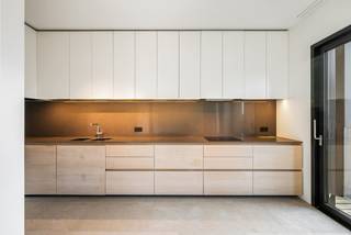 Op de 4e verdieping van het gerenommeerde woonproject Het Kanaal in Wijnegem bevindt zich dit bijzonder lichtrijke appartement met een bewoonbare oppervlakte van ca. 148 m² en een ruim overdekt terras van ca. 32 m². De combinatie van royale raampartijen, een plafondhoogte van bijna drie meter en een hoogwaardige materiaalkeuze zorgt voor een open en verfijnde woonbeleving.<br /><br />Het is mogelijk om hier indien gewenst meerdere slaapkamers te creëren.<br /><br />Het Kanaal vormt een uitzonderlijke woonomgeving waar industrieel erfgoed, hedendaagse architectuur, kunst en landschap samenkomen volgens de visie van Axel Vervoordt. De ligging aan het Albertkanaal biedt een bijzondere setting, terwijl Antwerpen, Schilde en de omliggende gemeenten vlot bereikbaar blijven.<br /><br />Indeling:<br />Het appartement is bereikbaar via de lift en opent in een ruime private inkomhal met vestiaire en geïntegreerde kastenwand. Natuursteen en maatwerk zetten meteen de toon. Aansluitend bevindt zich een afzonderlijk gastentoilet.<br /><br />De royale leefruimte van ca. 50 m² is afgewerkt met parket en wordt aan verschillende zijden omgeven door grote glaspartijen. Hierdoor geniet het interieur van een overvloed aan natuurlijk licht en mooie zichten op de omgeving. Een groot schuifraam geeft rechtstreeks toegang tot het overdekte terras van ca. 32 m², dat een aangename uitbreiding vormt van de woonruimte.<br /><br />Aansluitend bevinden zich de eetkamer van ca. 20 m² en de volledig ingerichte keuken van eveneens ca. 20 m². De keuken is uitgevoerd op natuursteen en voorzien van kwalitatieve inbouwtoestellen, waaronder toestellen van Miele, AEG en Novy.<br /><br />Een polyvalente ruimte van ca. 16 m², momenteel ingericht als dressing, vormt de overgang naar het private slaapgedeelte. De slaapkamer van ca. 16 m² beschikt over parketvloer en toegang tot een balkon.<br /><br />De ruime badkamer van ca. 13 m² is uitgevoerd in Carrara-marmer en voorzien van een vrijstaand ligbad, inloopdouche, dubbel lavabomeubel, handdoekradiator en afzonderlijk toilet. Verder beschikt het appartement over een praktische wasplaats met uitgietbak en technische voorzieningen.<br /><br />Bijzonderheden:<br />- Overdekt terras van ca. 32 m² met zicht op kanaal<br />- Royale plafondhoogte van ca. 2,92 m<br />- Uitzonderlijk veel natuurlijke lichtinval dankzij de grote raampartijen<br />- Royale leefruimte van ca. 50 m²<br />- Polyvalente ruimte, momenteel ingericht als dressing<br />- Lift aanwezig<br />- 2 ondergrondse autostaanplaatsen op niveau -1<br />- Vanuit garage met lift direct toegang tot app<br />- Automatische toegangspoort en videofoon<br />- EPC-label A, 82 kWh/(m² jaar)<br /><br />Unieke ligging binnen Het Kanaal, het internationaal gerenommeerde woon- en kunstproject van Axel Vervoordt